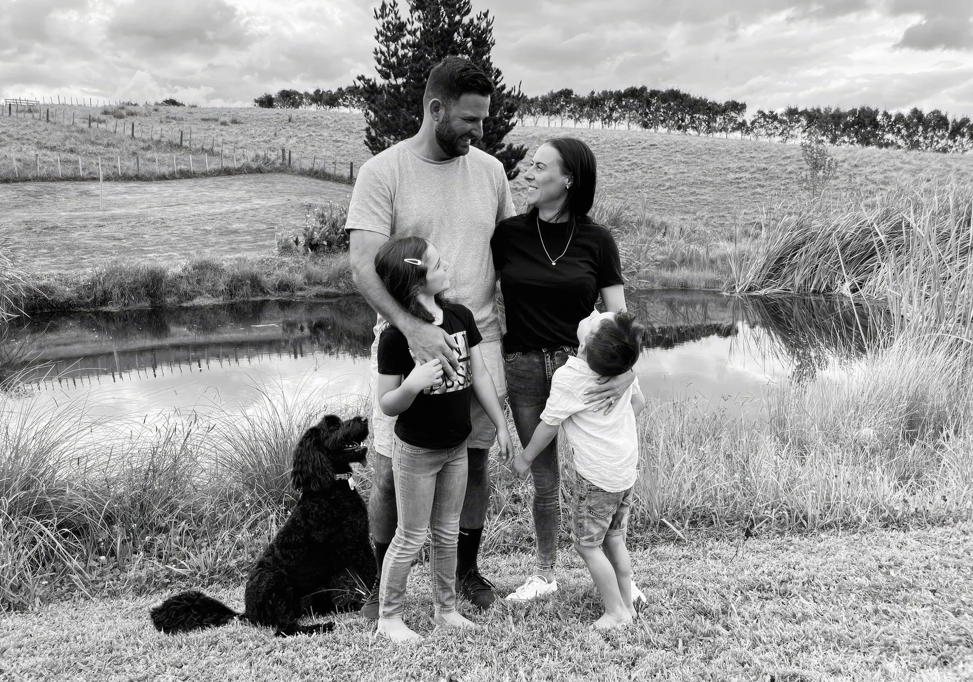 Black and white Family PortraitJosh and Fi Gillanders, founders of Elite Building, with their family at their Mangawhai property