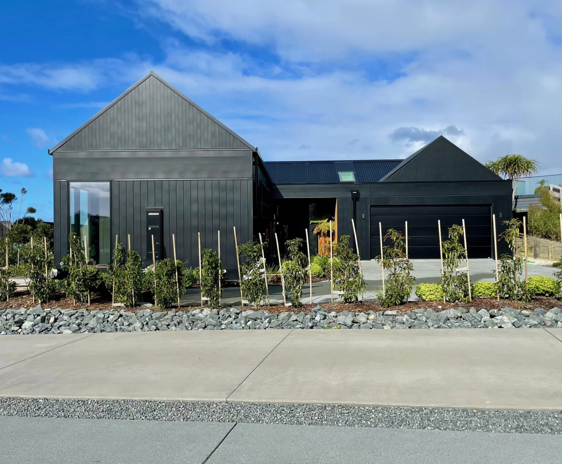Sand Dune luxury new home exterior with landscaped garden beds, Mangawhai