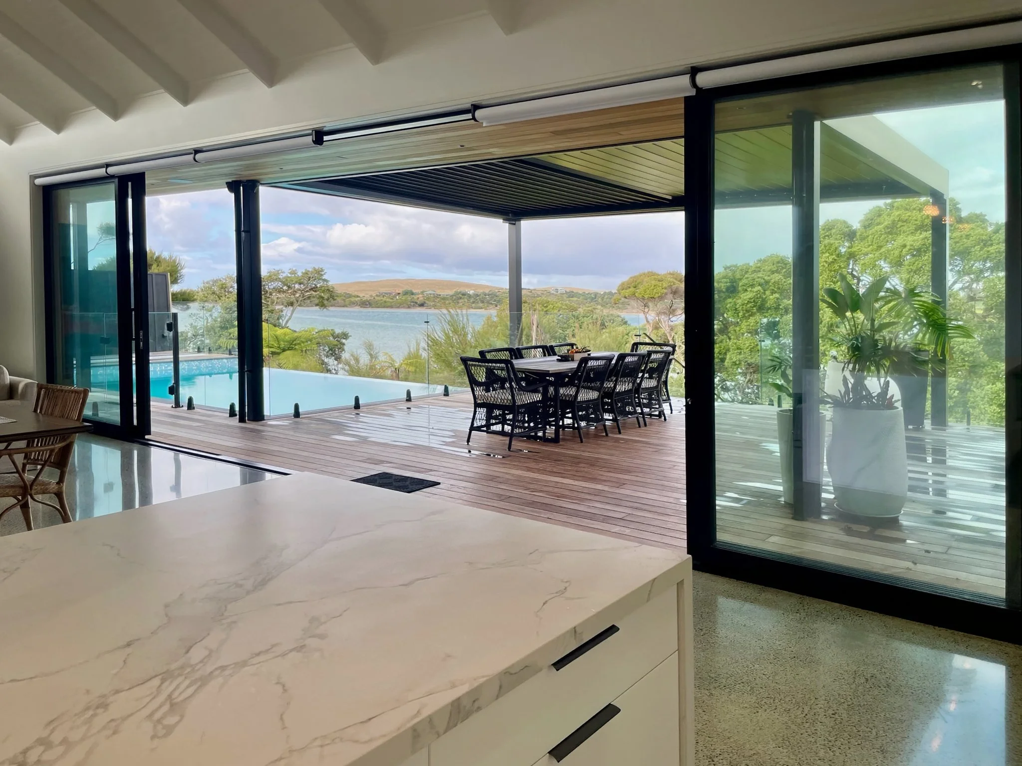 Sand Dune new home indoor outdoor flow opening to pool deck and harbour views, Mangawhai