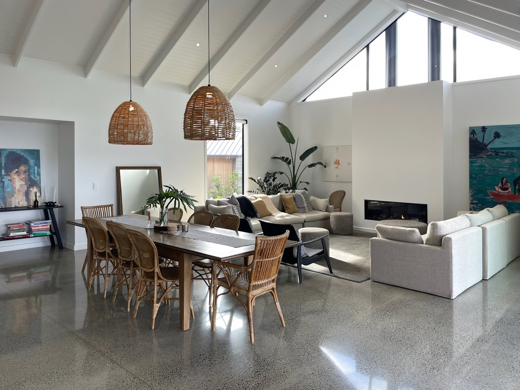 Sand Dune open plan dining and living with vaulted ceiling and rattan pendants, Mangawhai