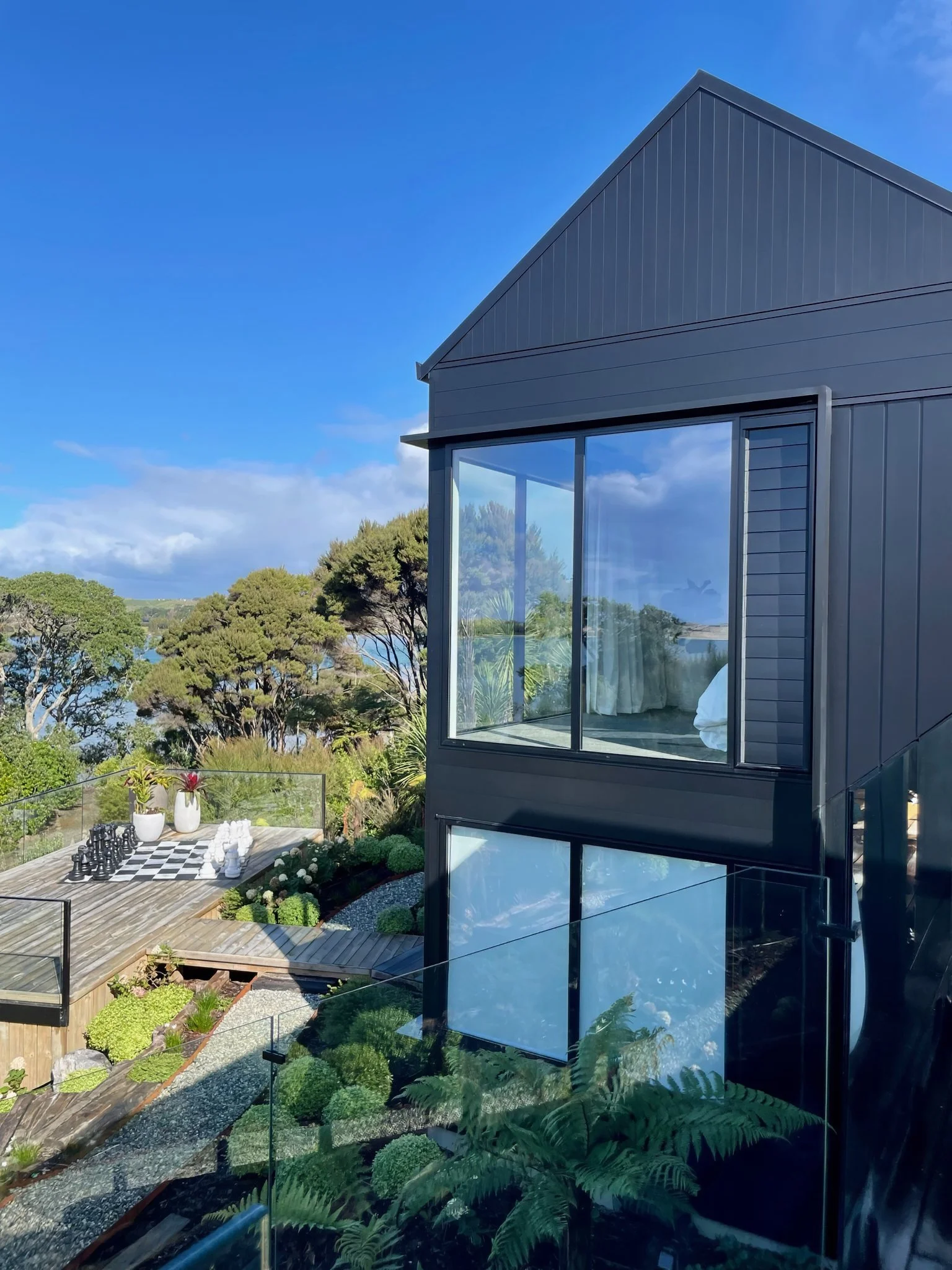 Sand Dune luxury new home dark cladding and floor to ceiling windows, Northland