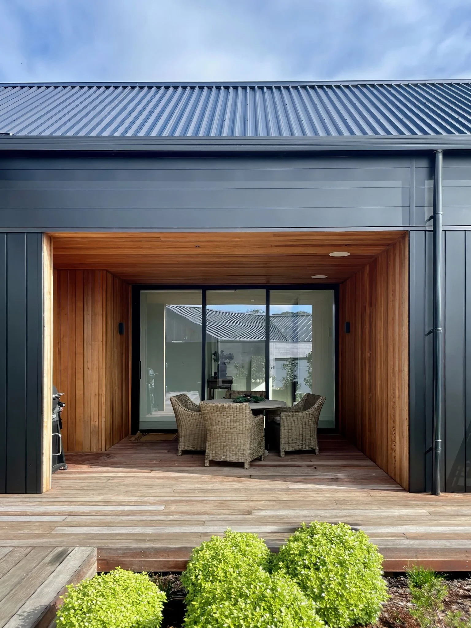 Sand Dune luxury outdoor living room with timber framing and harbour views, Mangawhai