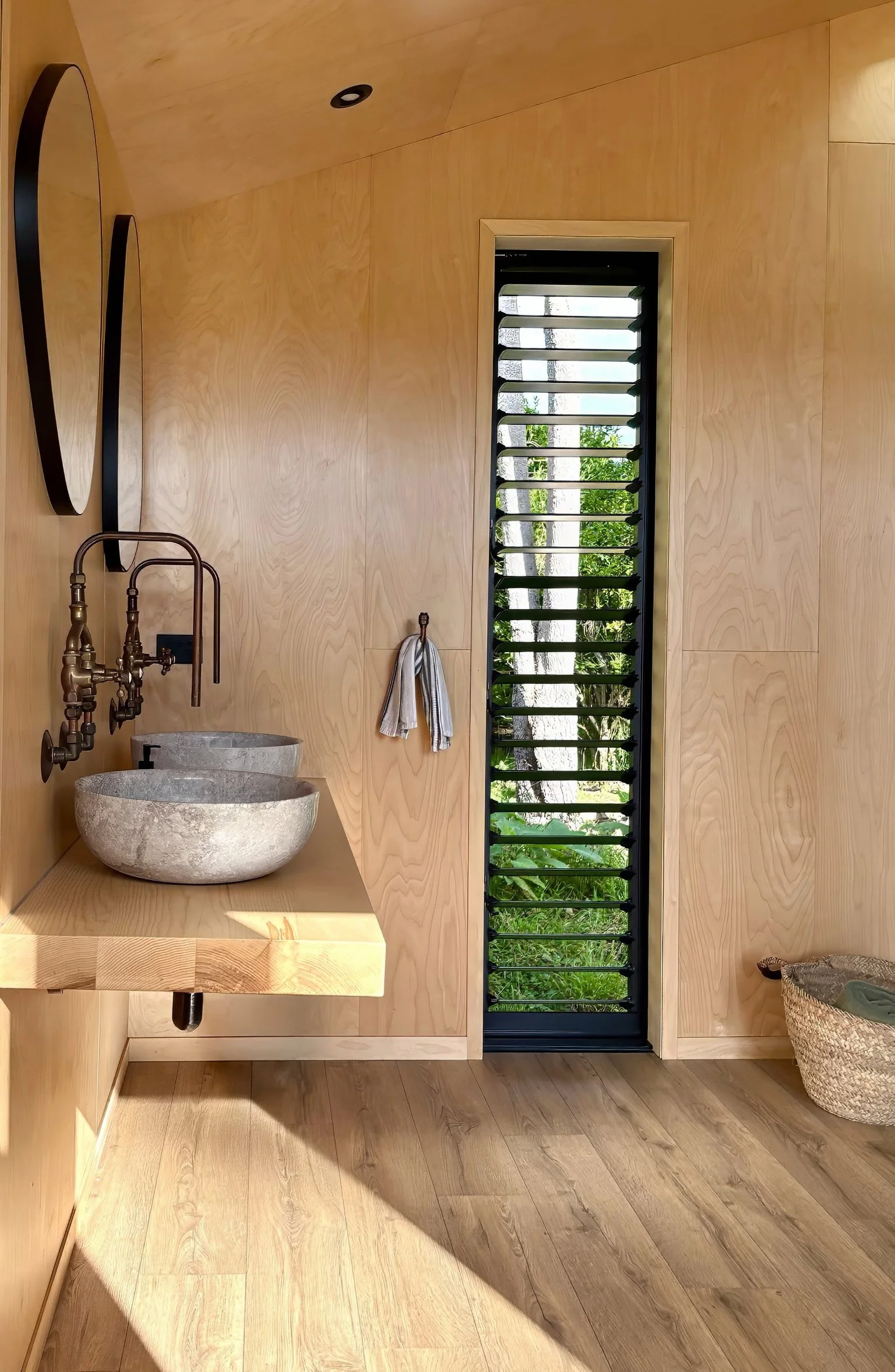 Antique brass tapware and stone vanity bowls, luxury glamping bathroom Mangawhai. Custom American ash vanity with stone bowls, Black Swamp glamping bathroom