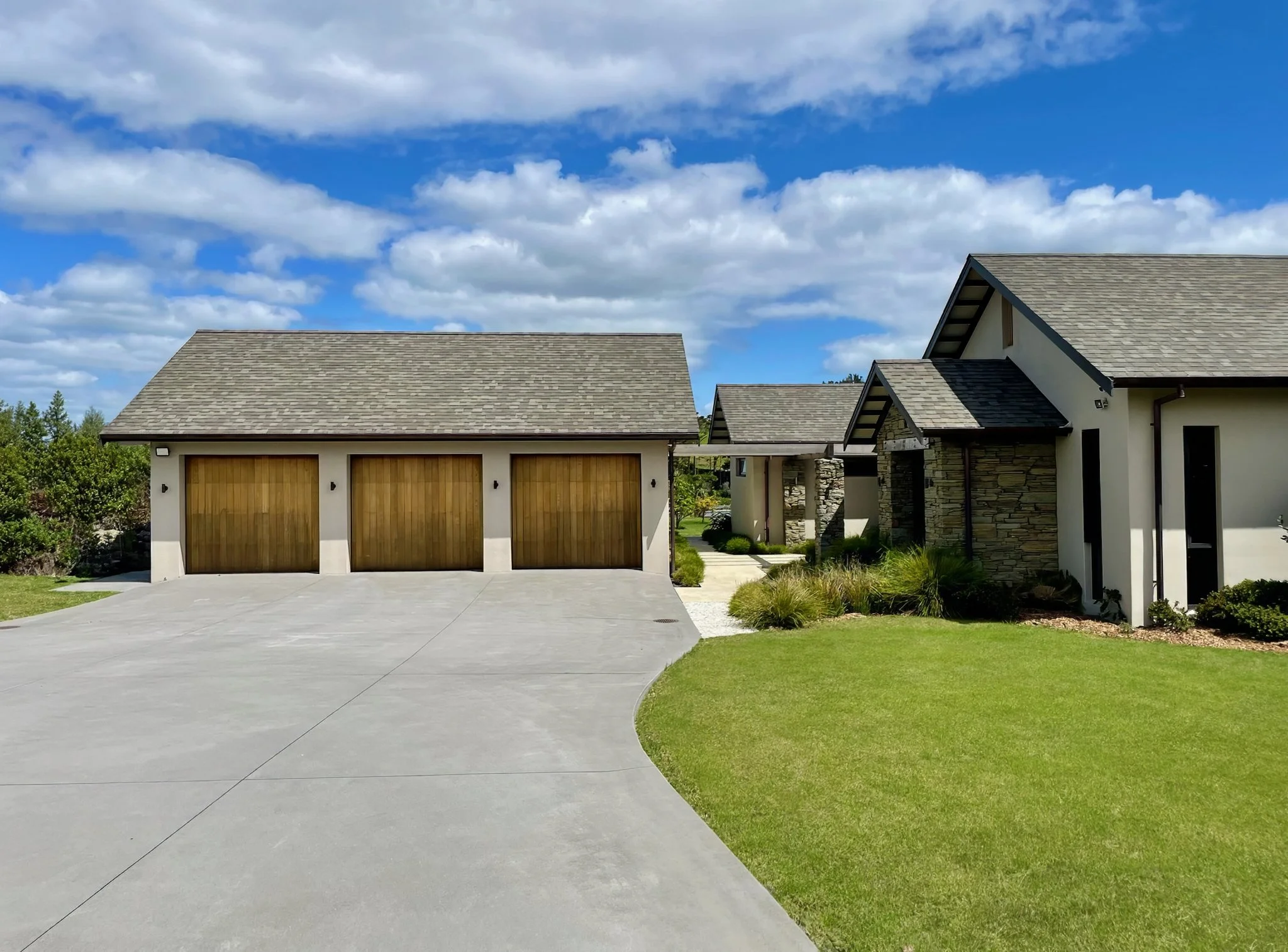 Sanctuary Lakeview luxury new home exterior with garage and manicured lawn, Mangawhai