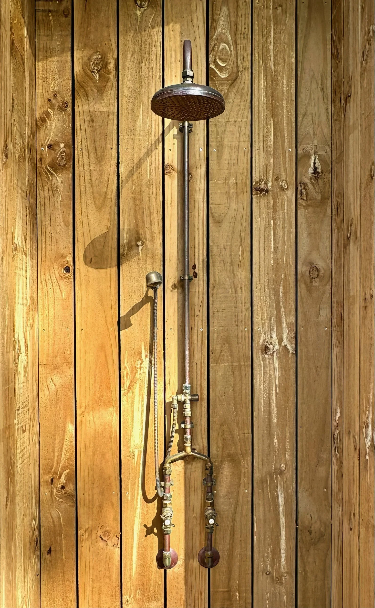 Outdoor shower with timber facade, Black Swamp glamping lodge Northland
