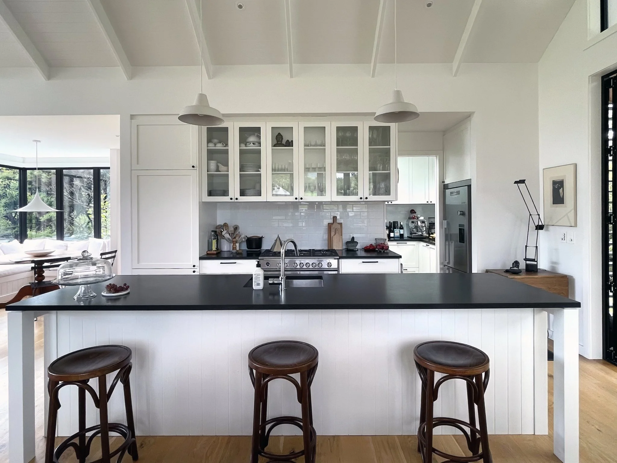Luxury white kitchen with glass cabinetry and black benchtop, Waiotahi Drive Elite Building Mangawhai