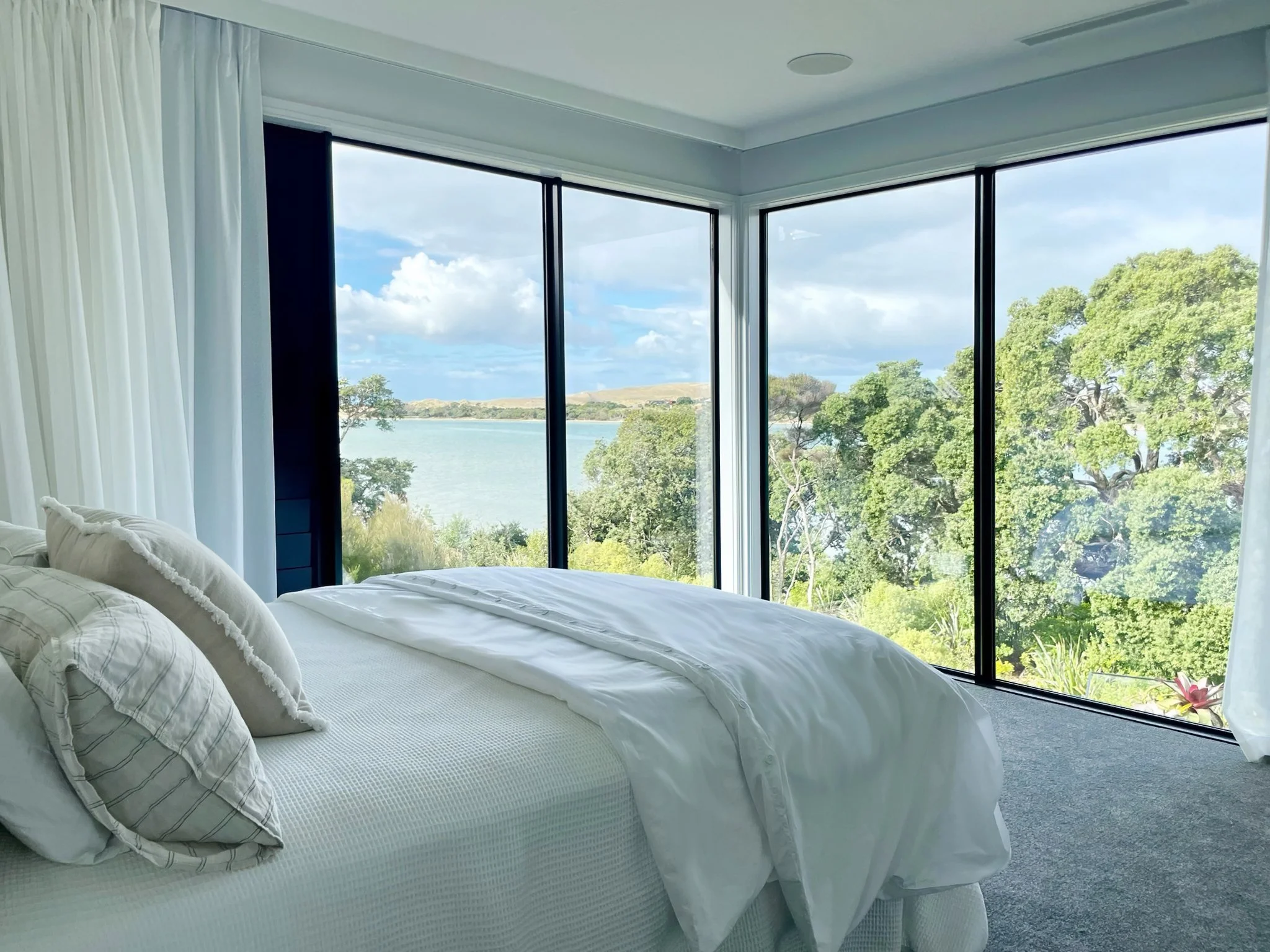 Sand Dune master bedroom with corner windows and harbour views, Elite Building Mangawhai