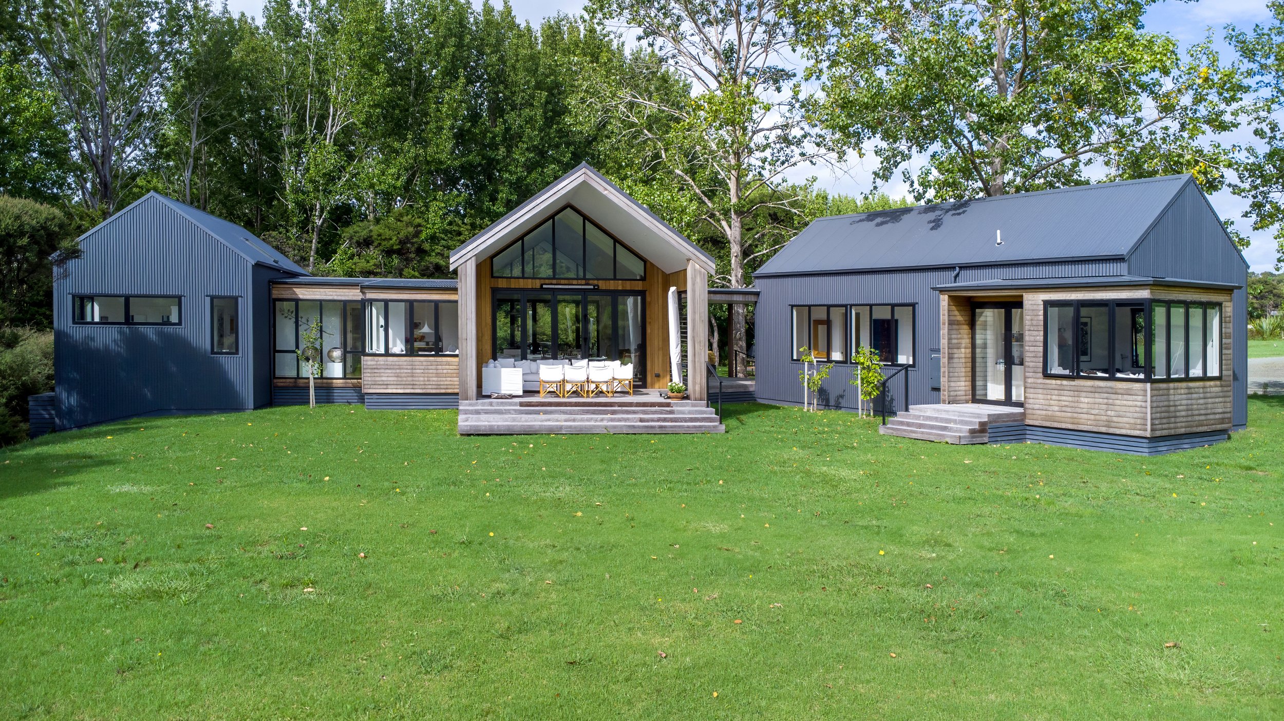 Modern luxury new home exterior with gabled roof and landscaped lawn, Elite Building Mangawhai