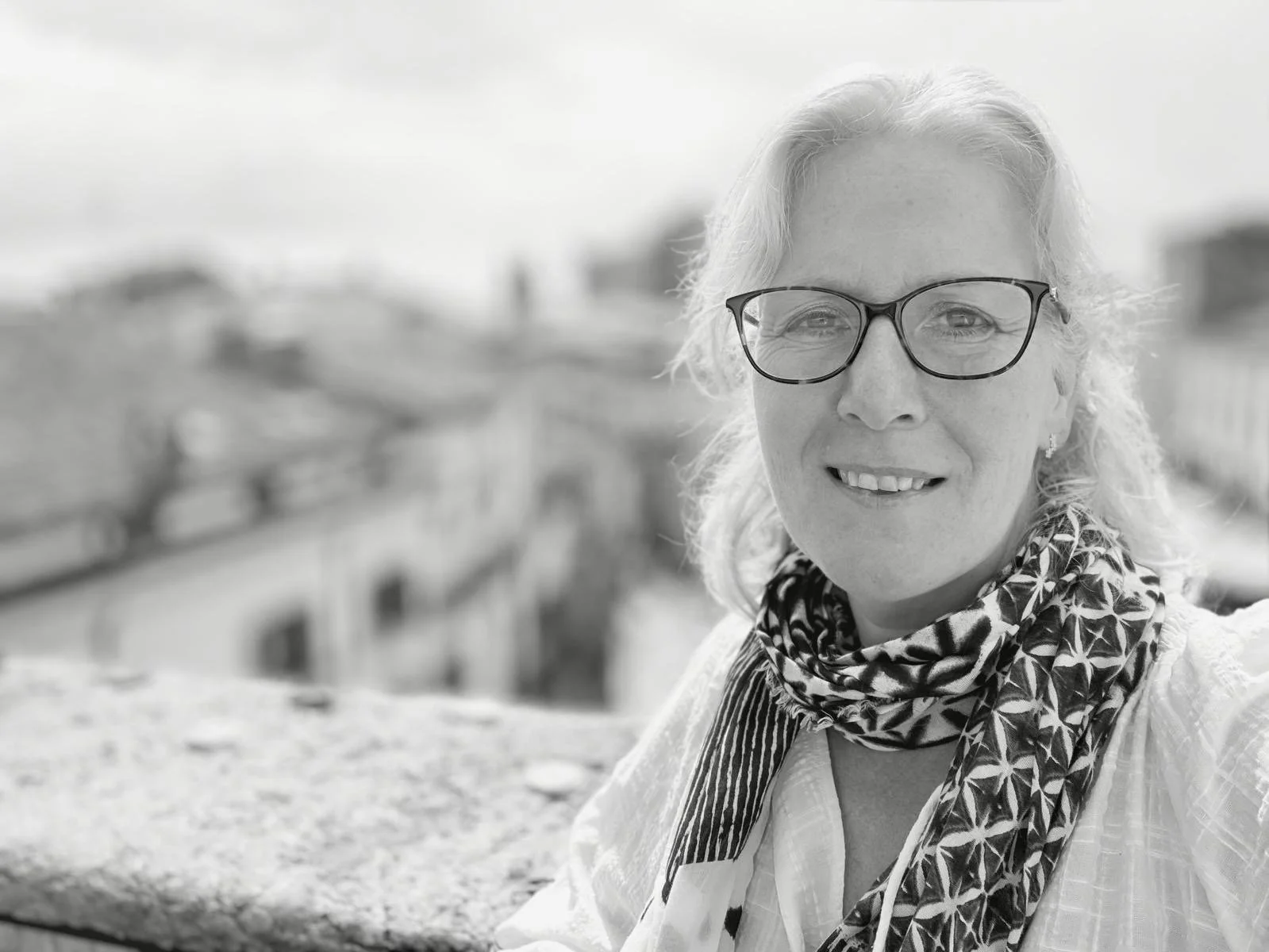 Black and white photo, Rachael is wearing a scarf and glasses with long hair
