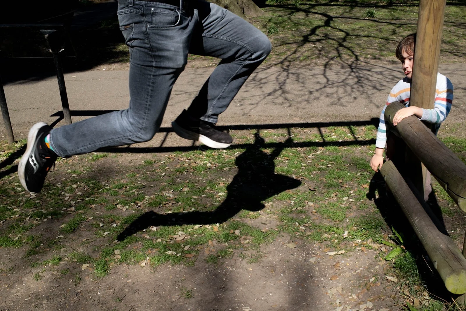 Father and son playing on monkey bars during a documentary family photography session in North London