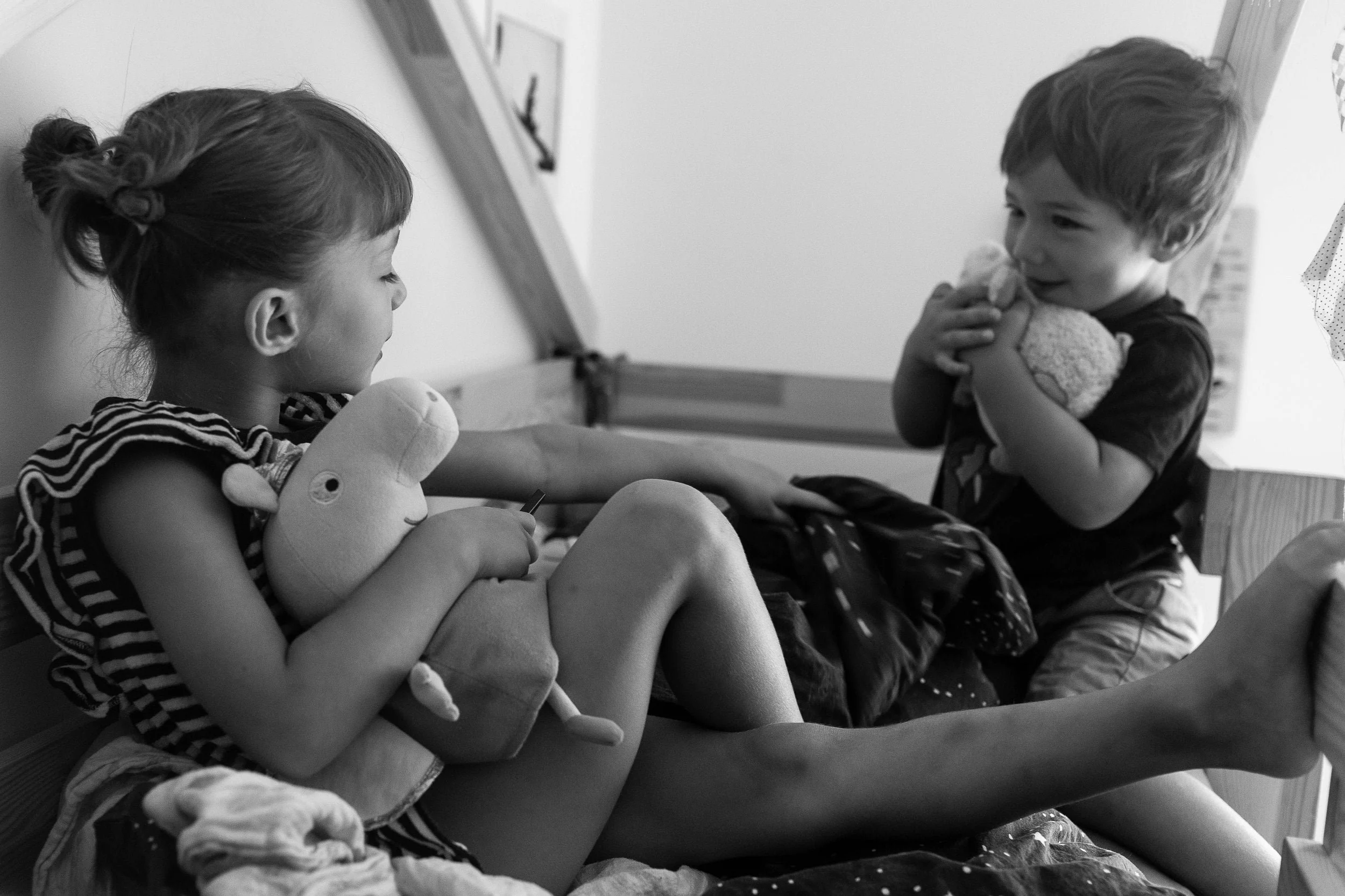 Two young children smiling with stuffed animals, captured in a cozy, playful setting—perfect family photography in Tufnell Park North London.