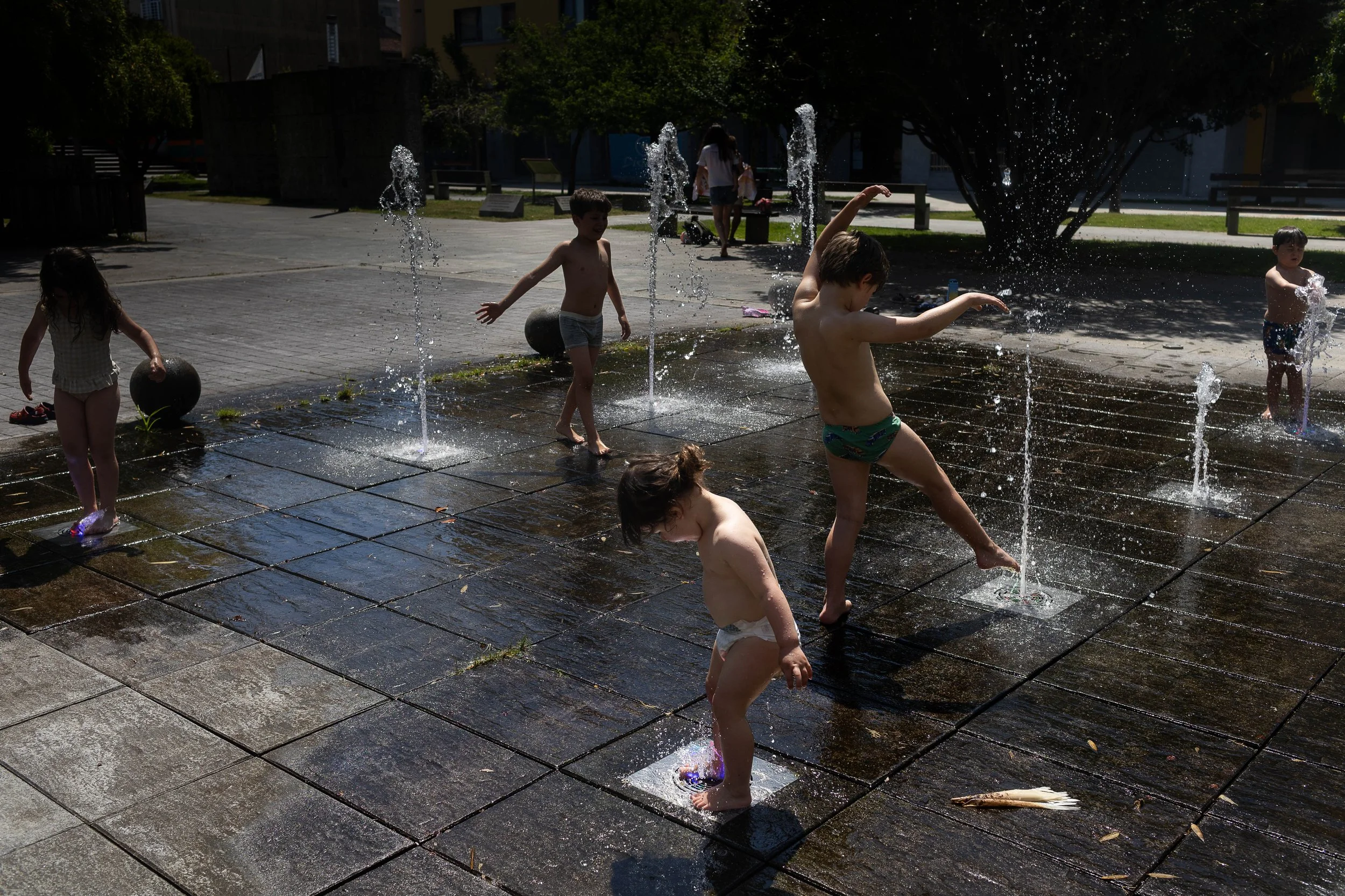 North London family photography - children playing in a fountain at Kings Cross Coal Drops Yard