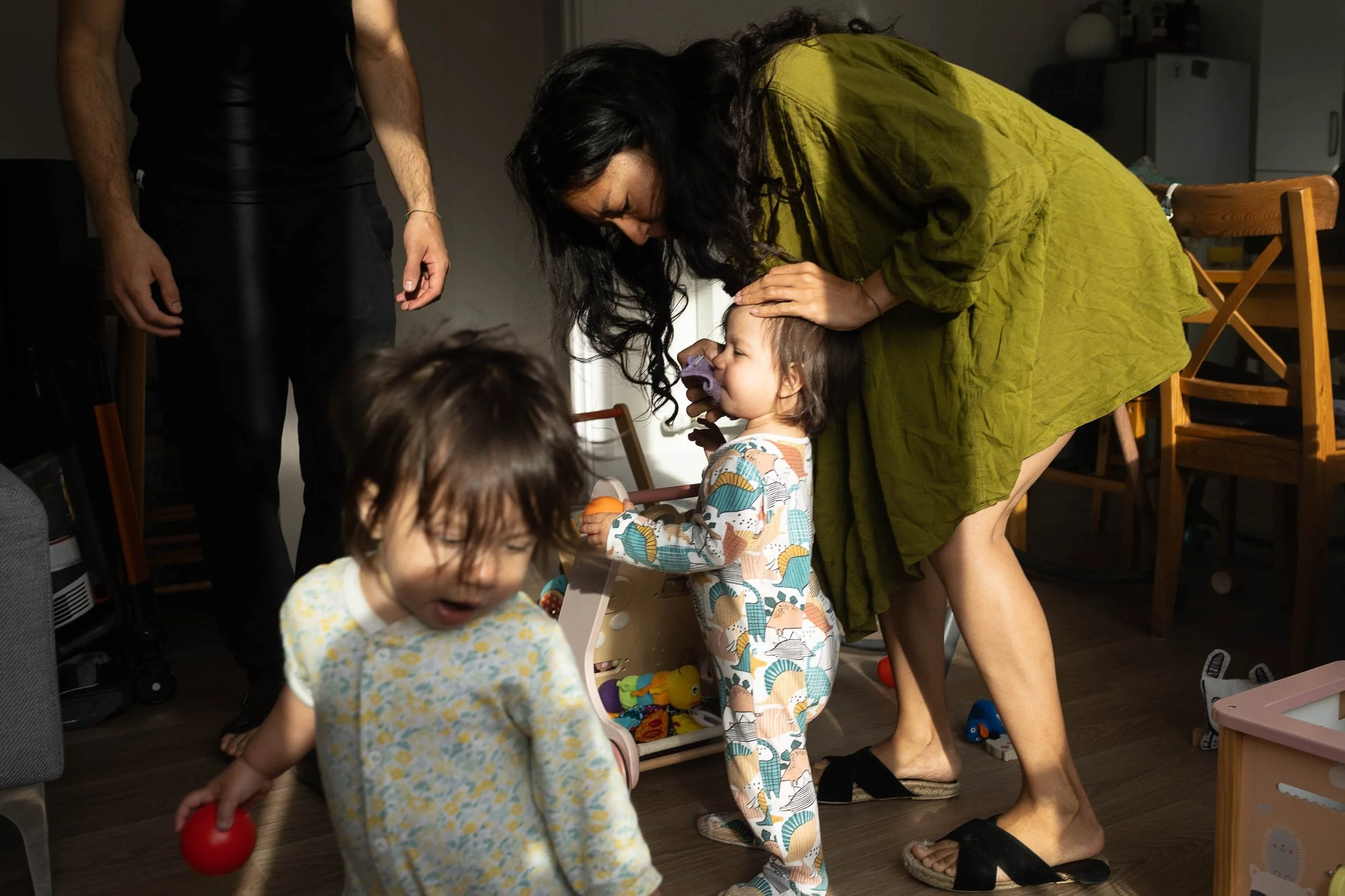 Twin toddler having a nose wipe during a family photo shoot in Highbury and Islington