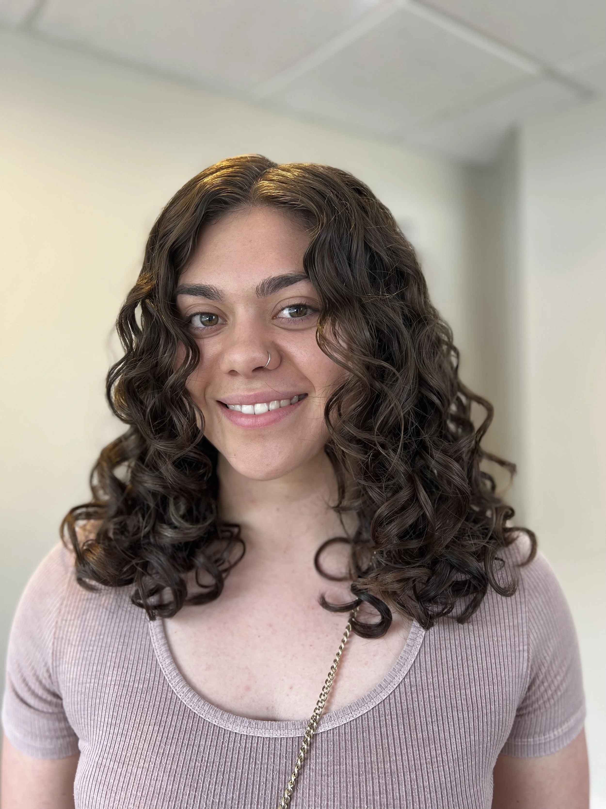Woman with bouncy and voluminous 2B curls after a haircut.