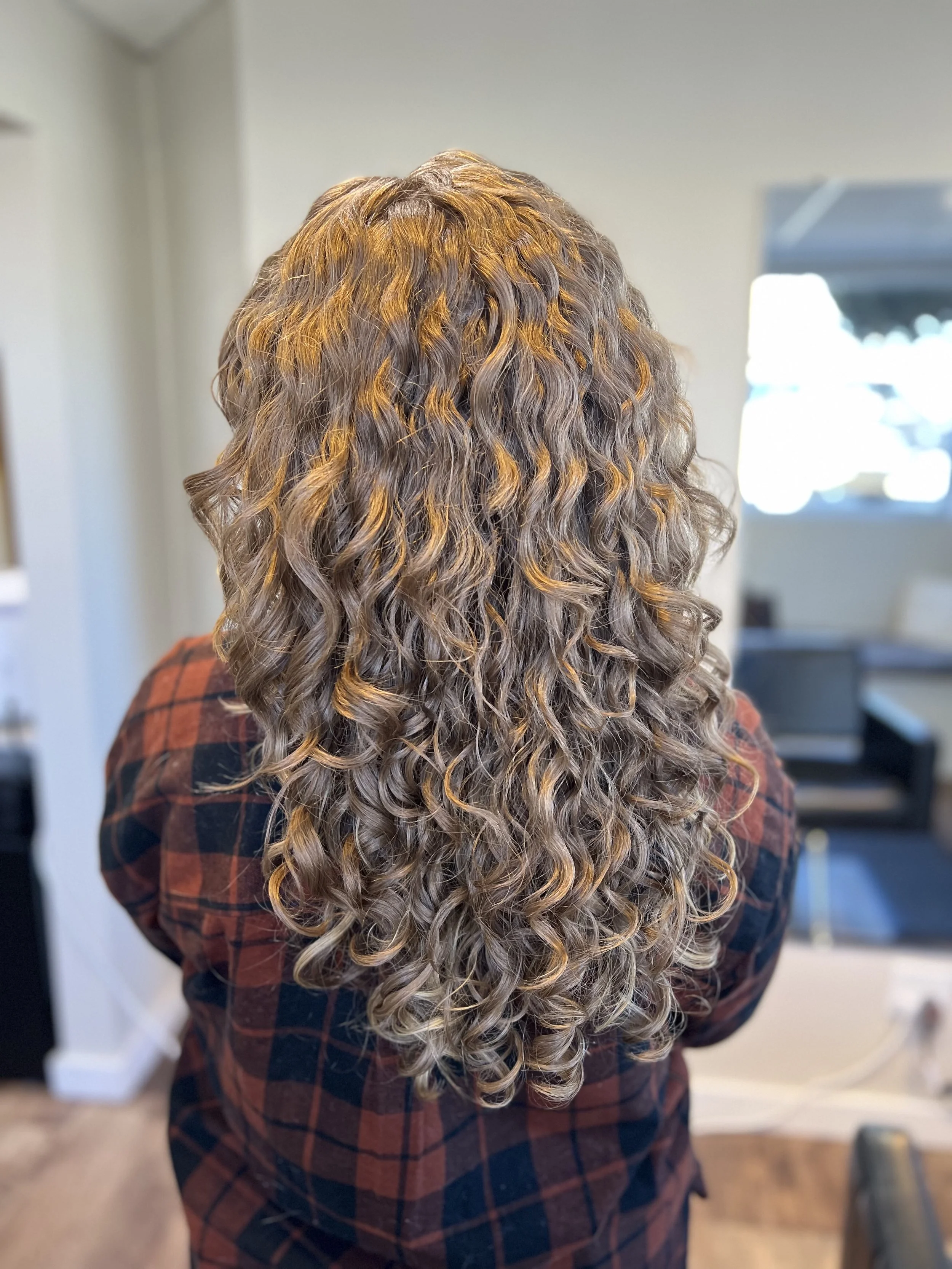 Woman with beautiful curls after a detox treatment and curly haircut.
