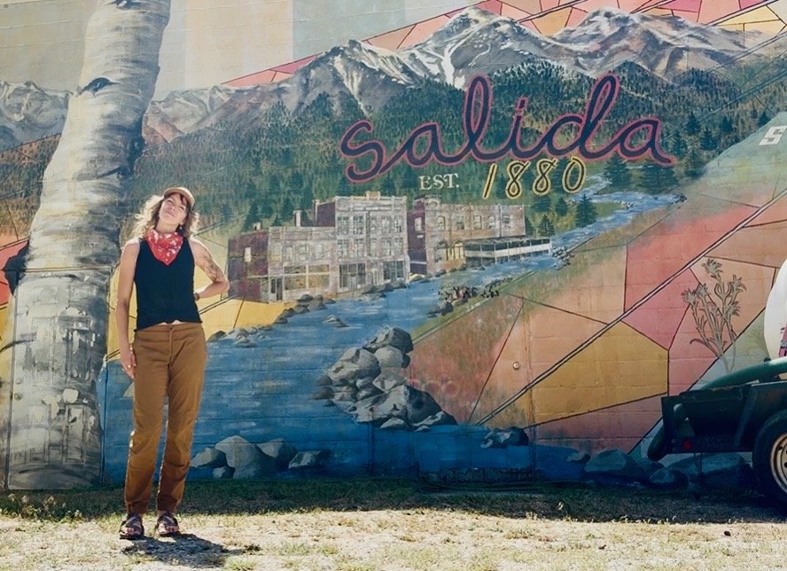 woman standing in front of mural in Salida, Colorado reflecting on burnout during a solo road trip