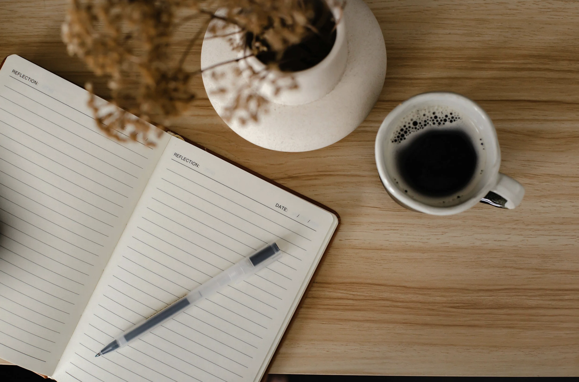 Desk with coffee and journal representing thoughtful writing about burnout, healing, and attention.