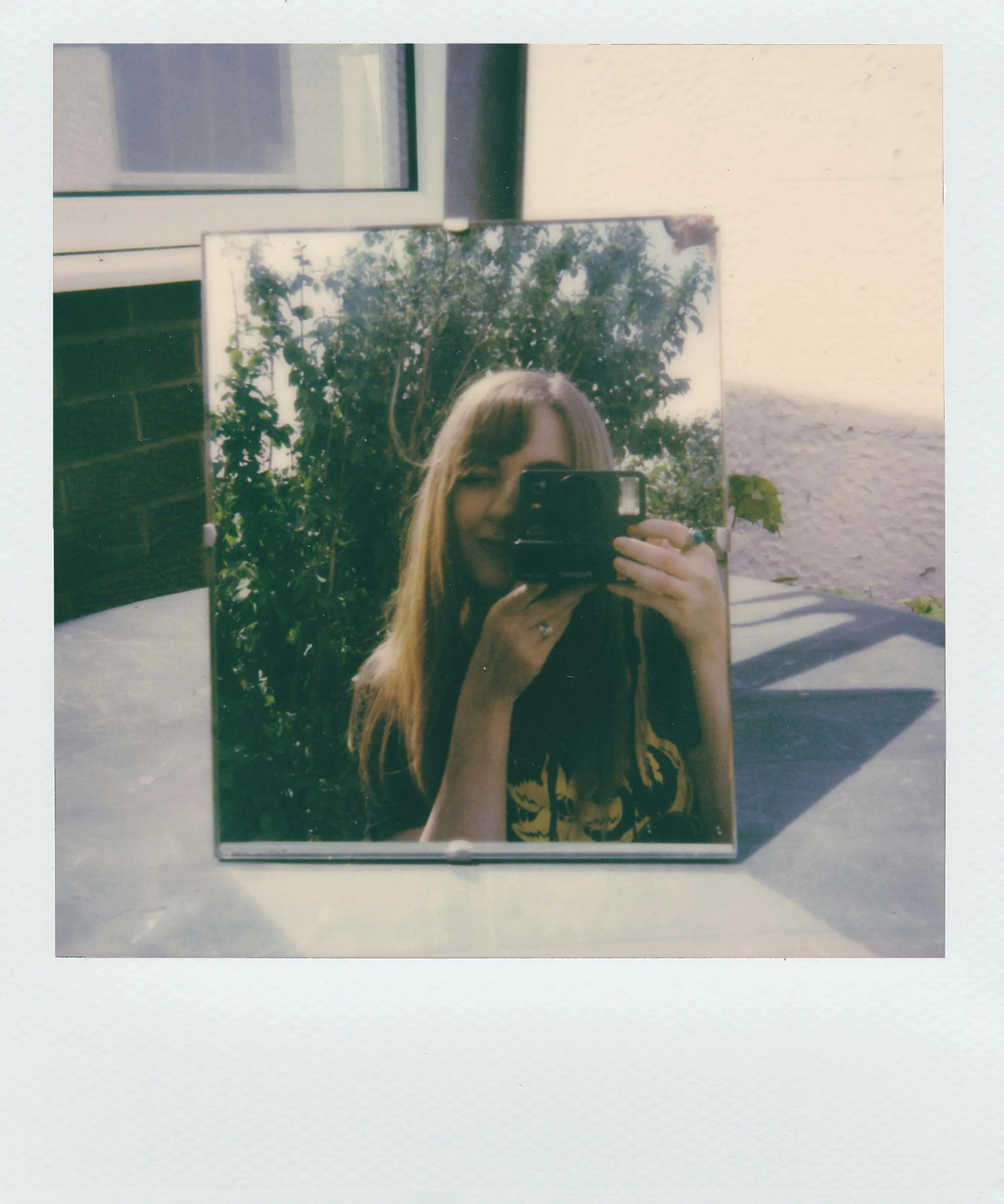 Polaroid of a woman reflected in a mirror outside, part of an anonymised ED recovery quote series for Ianthe House.