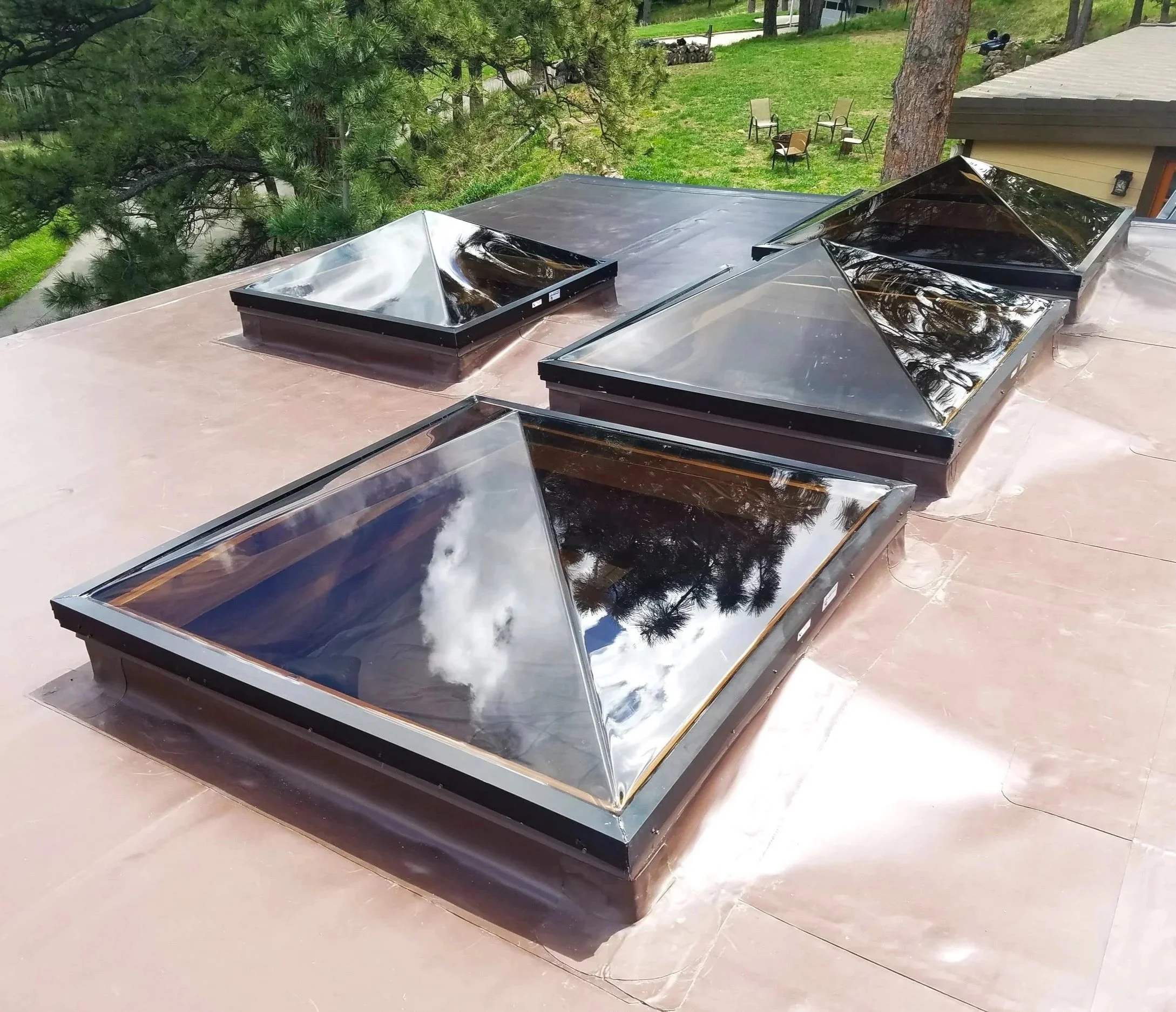 Pyramid acrylic thermoformed skylights on a flat roof.