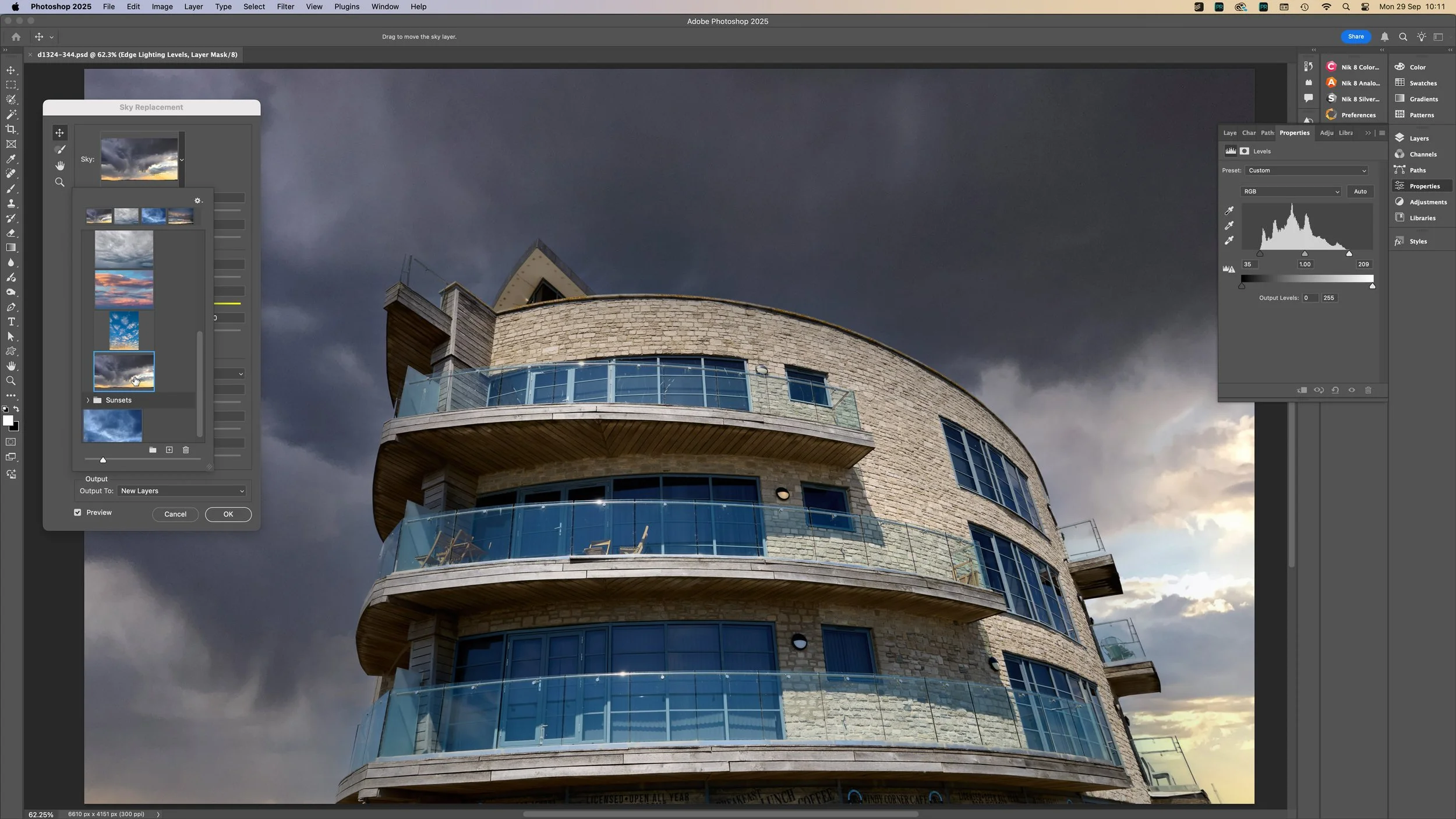 Een moderne, ronde gebouw met meerdere verdiepingen en grote glazen balkonramen onder een donkere, dreigende wolkenlucht.