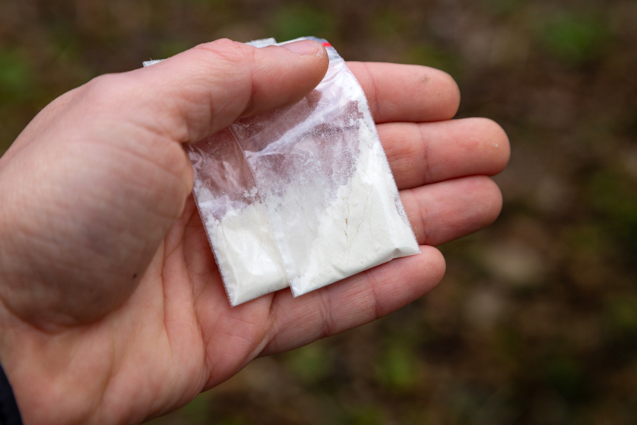 man holding two bags of cocaine
