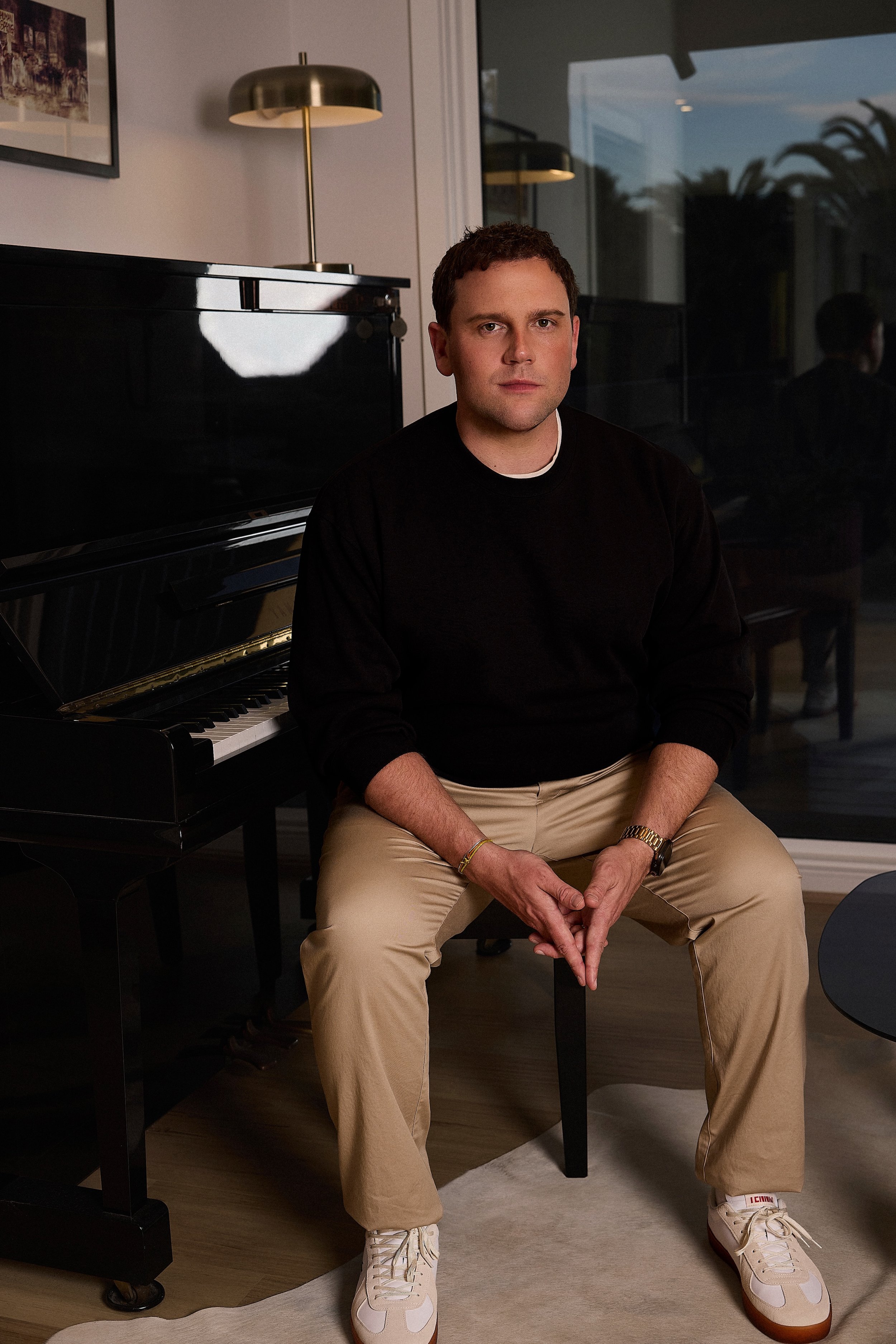 2026 portrait of Josh Simons, entrepreneur and CEO of Vinyl Group, seated beside a piano.