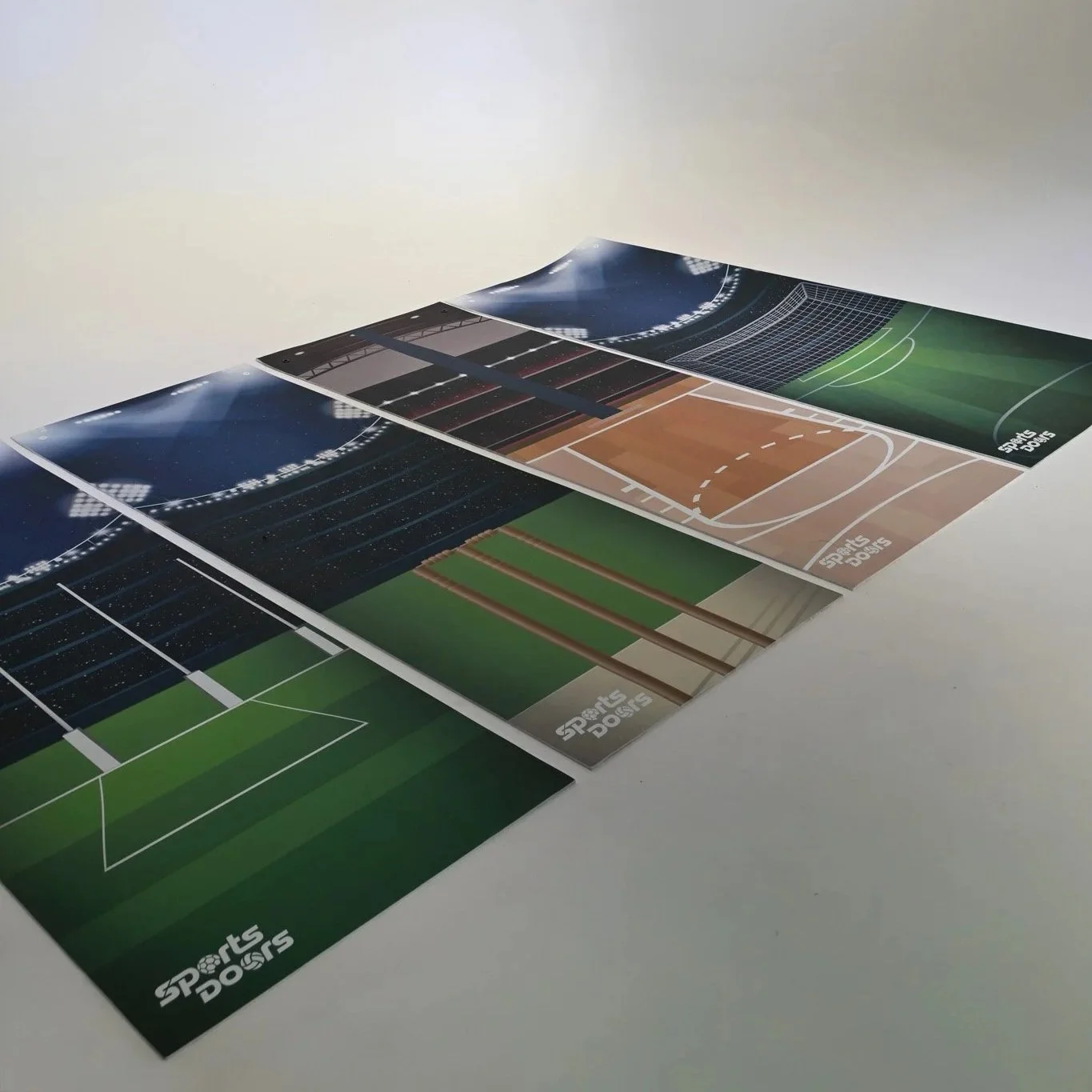 Sports Doors range of soft foam door hangers. Themes are soccer, basketball, AFL and cricket, each set in a sports stadium on a white surface.