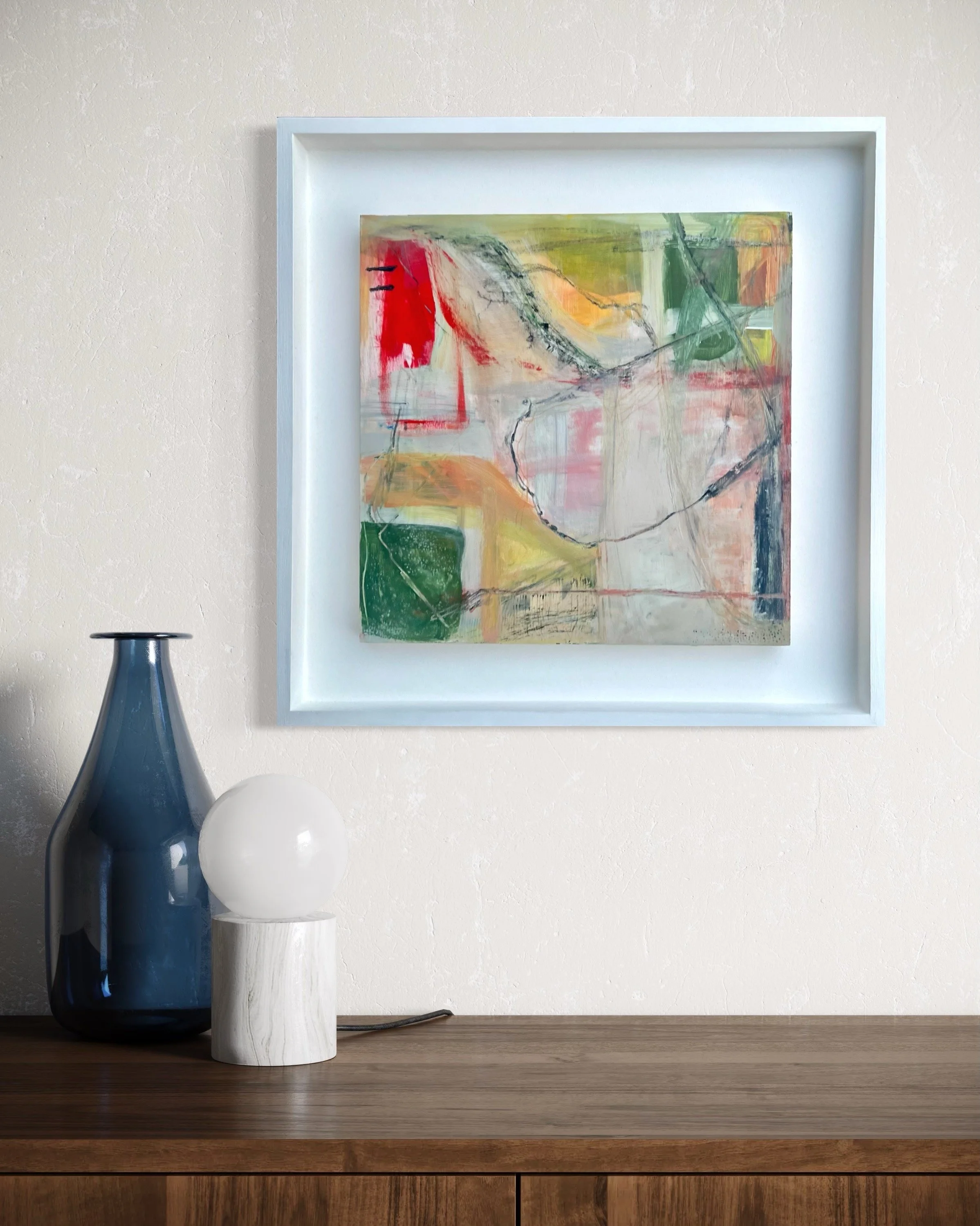 Inside Weather by Gera Dunachie displayed in a minimalist interior above a wooden console table; abstract composition in muted greens and warm neutrals with dynamic graphite linework.