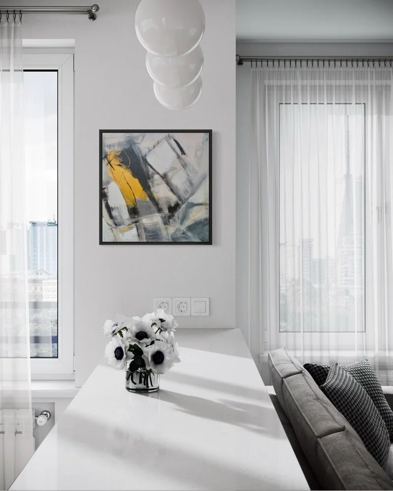 Forced Through, abstract painting by Gera Dunachie in a black frame, displayed between two tall windows above a white dining table in a bright contemporary interior.