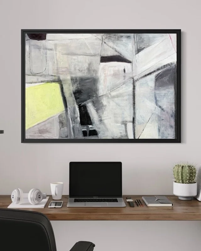 Tidal Zone by Gera Dunachie, a large abstract painting on wood panel, displayed in a black floating frame above a modern desk. The artwork features architectural grey tones and a vibrant lime yellow accent.