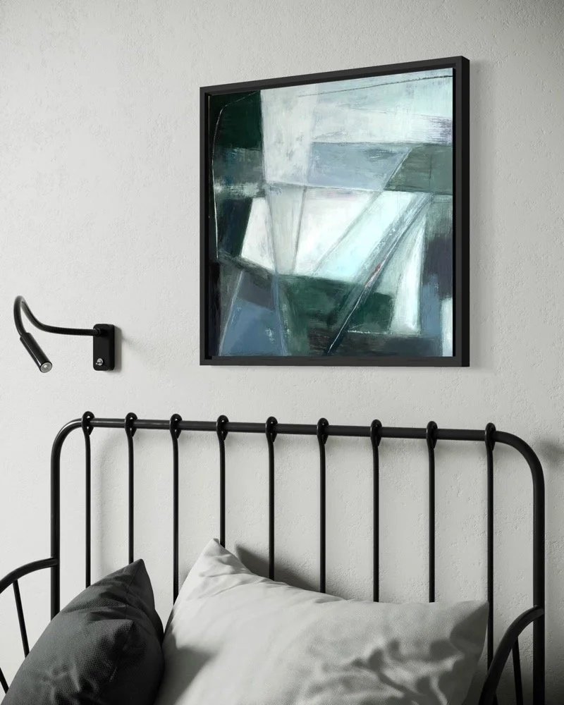 Abstract painting by Gera Dunachie showing grey blues, light and dark geometric shapes, displayed in black frame over a contemporary bedrest made of black railings.