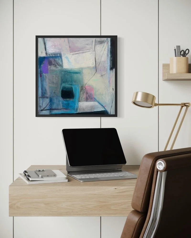Painting by Gera Dunachie in black frame hangs over a minimalistic working station