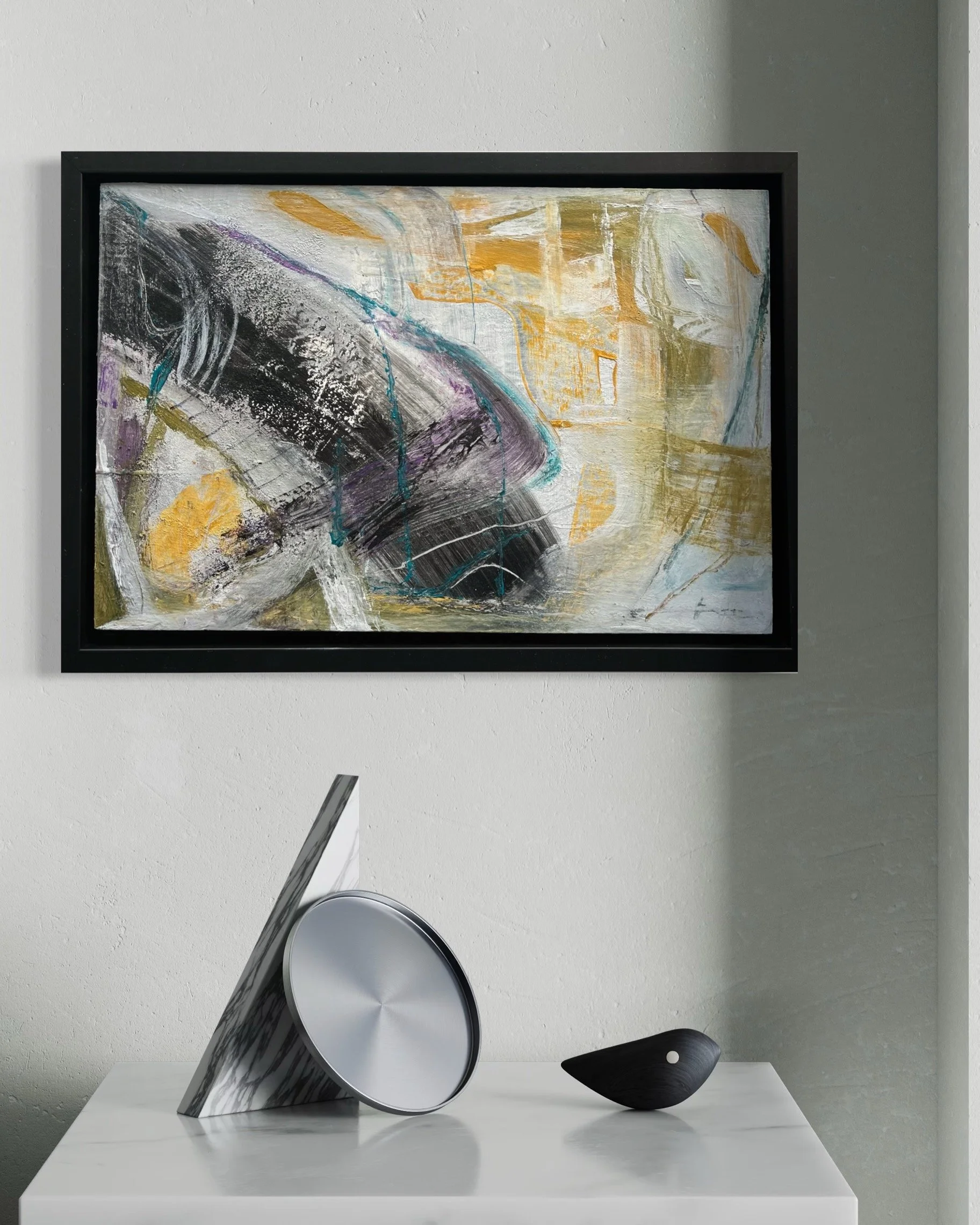 Snag, abstract painting by Gera Dunachie in a black frame, displayed above a white console with metallic sculptural objects in a minimal grey interior.