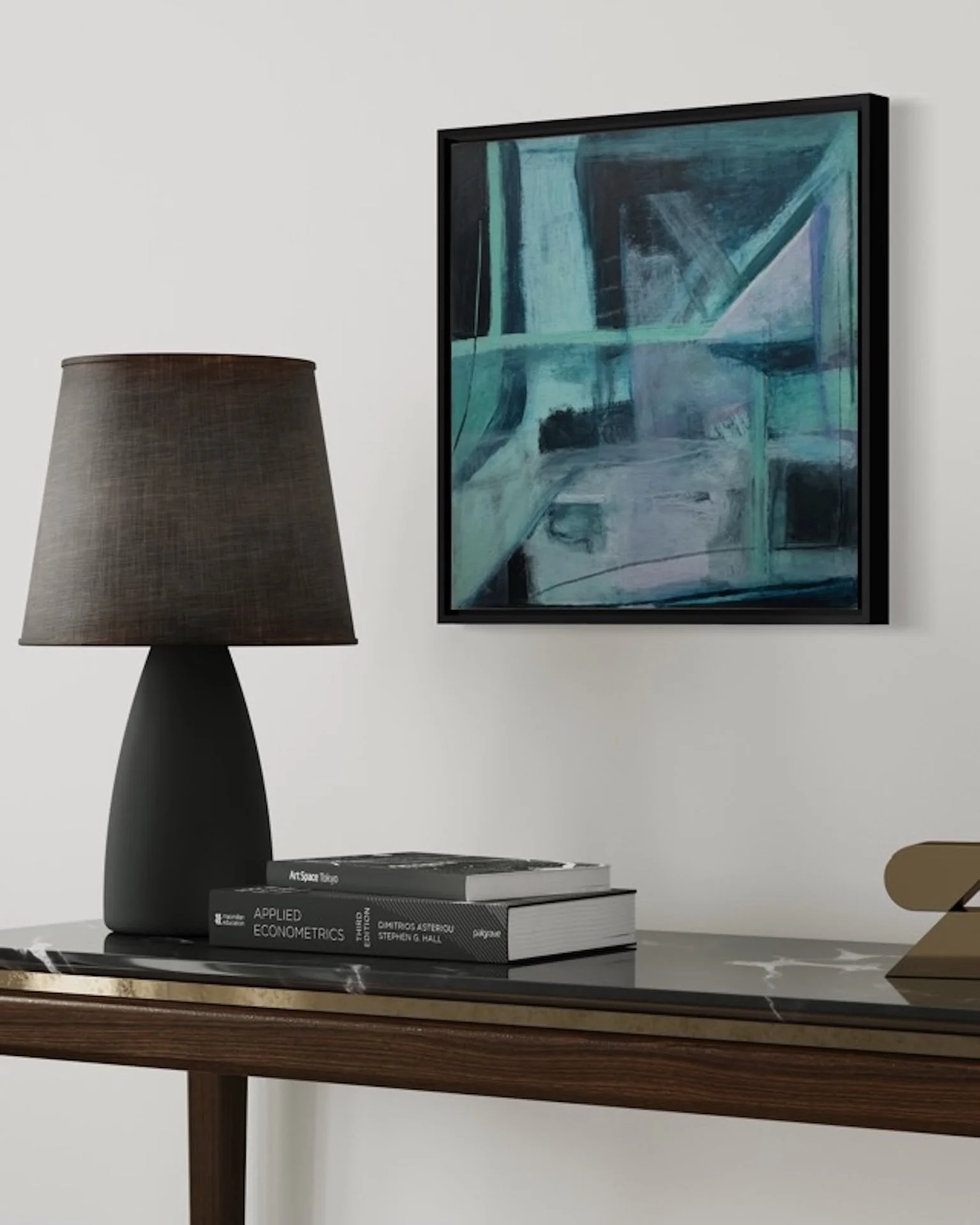 Below Threshold, abstract painting by Gera Dunachie in a black frame, displayed above a dark console with a table lamp and books in a minimalist neutral interior.
