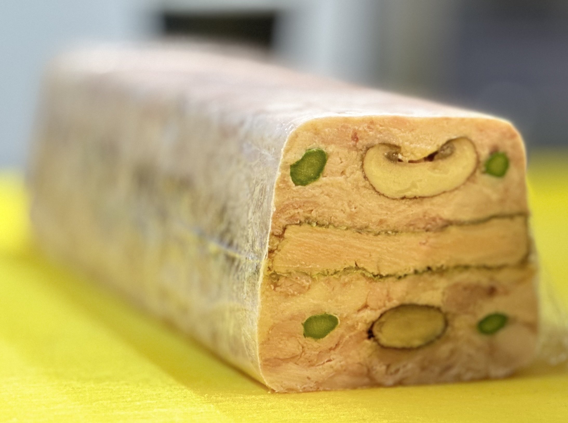 Close-up of a sliced layered terriene with chicken, foie gras and baby leeks and shiitake mushroom.