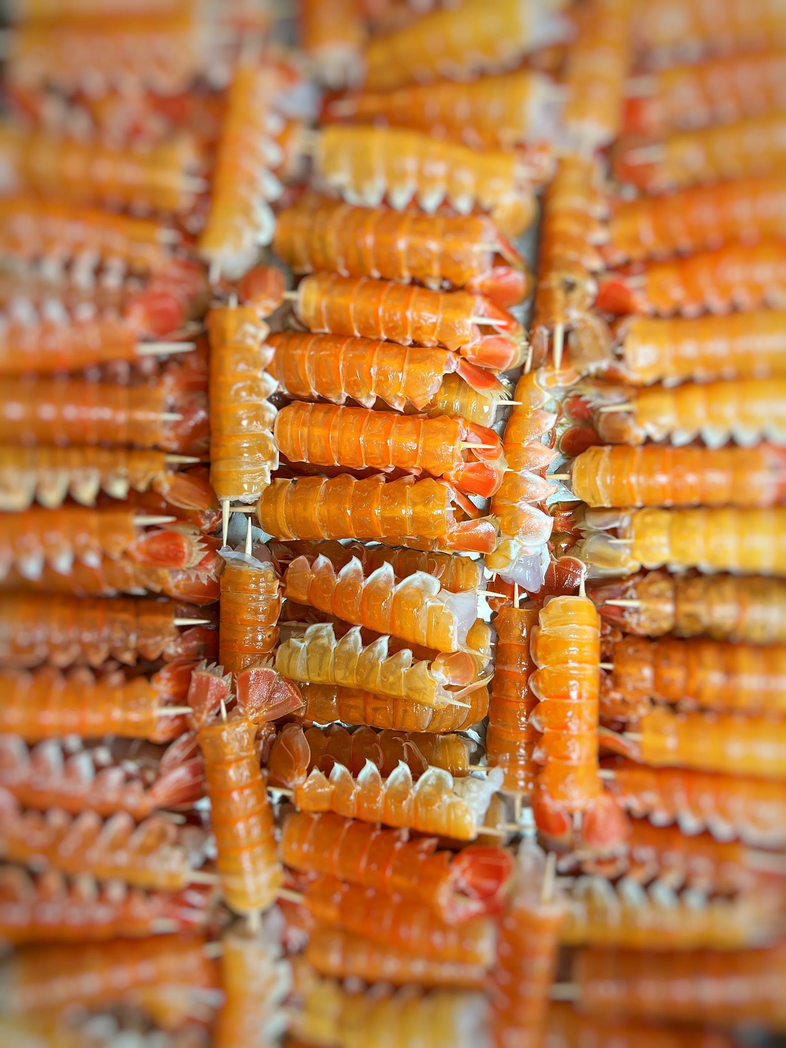 Close-up of orange and white taffy candies stretched and layered with toothpicks