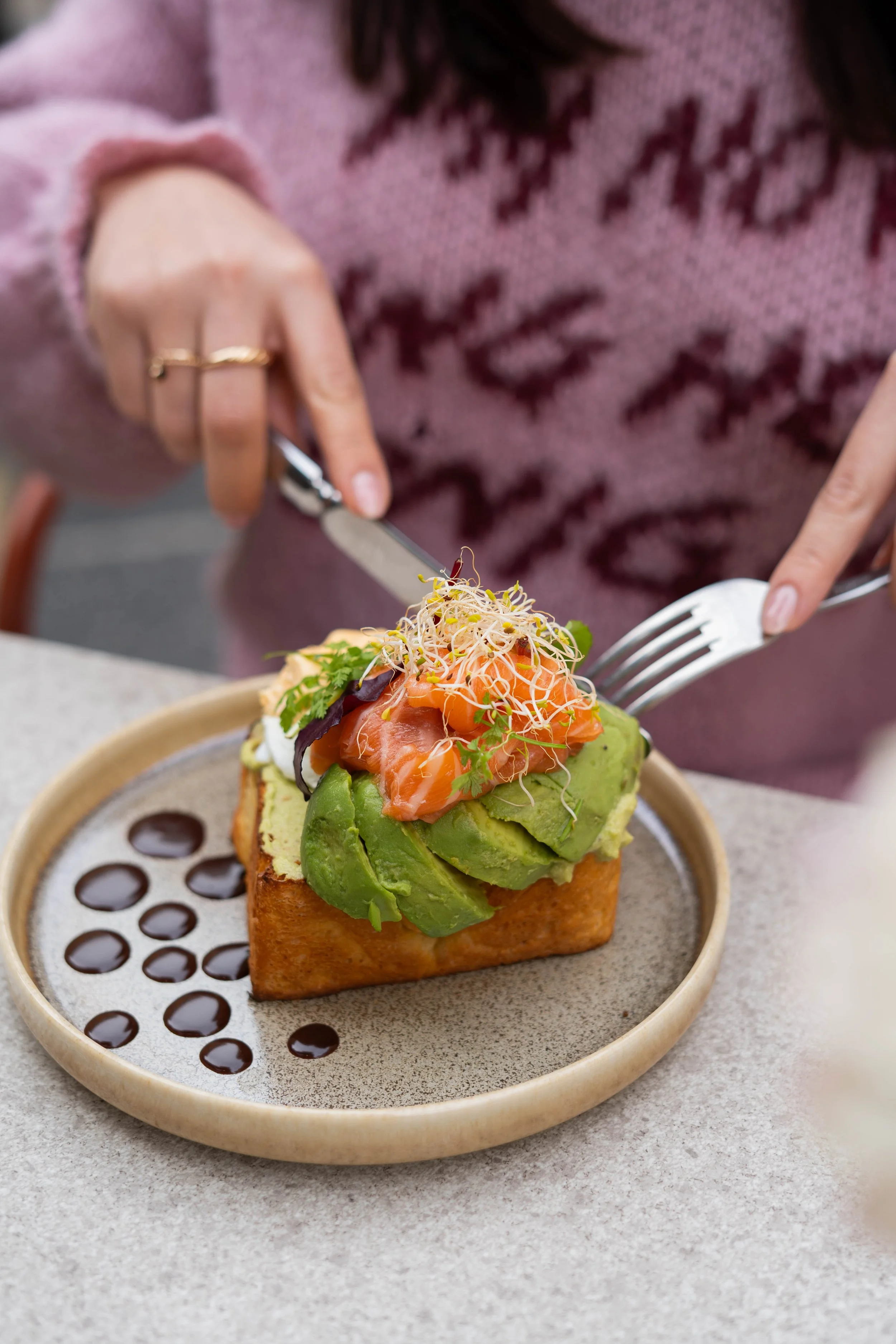 Une personne déguste une brioche avec des oeufs benedictes