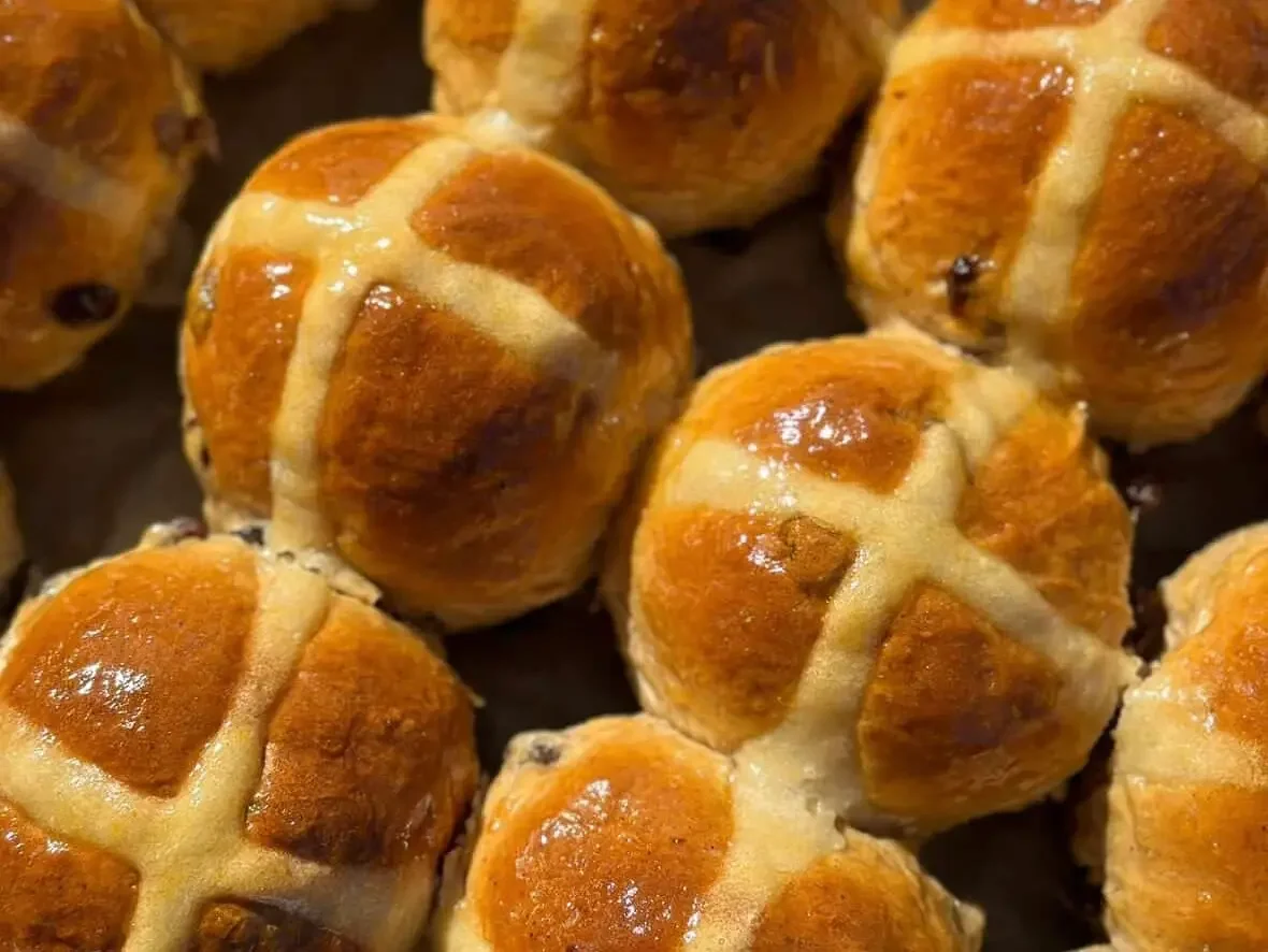 a close up of hot cross buns on a tray