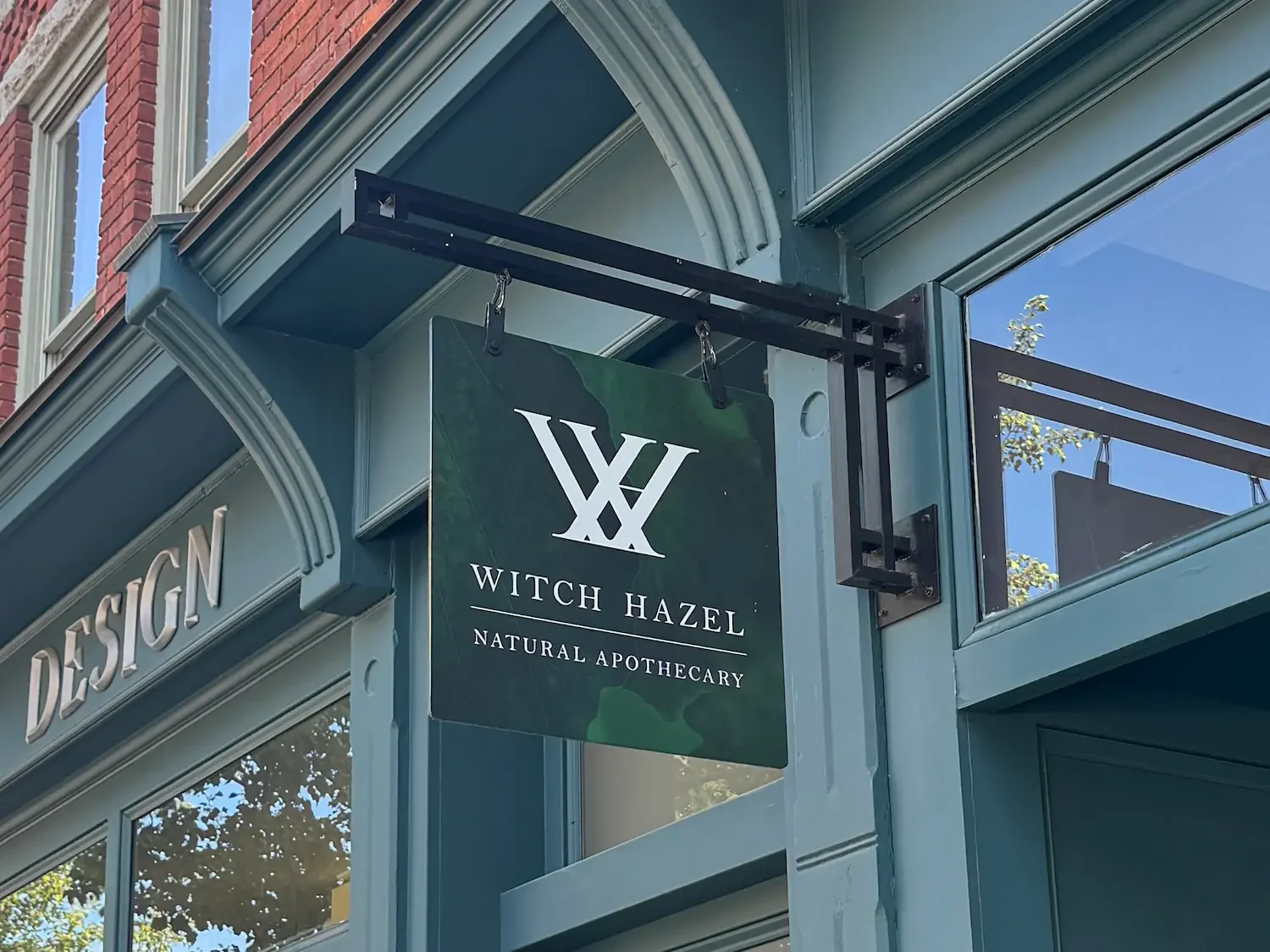 green sign with witch hazel wording on a shop front