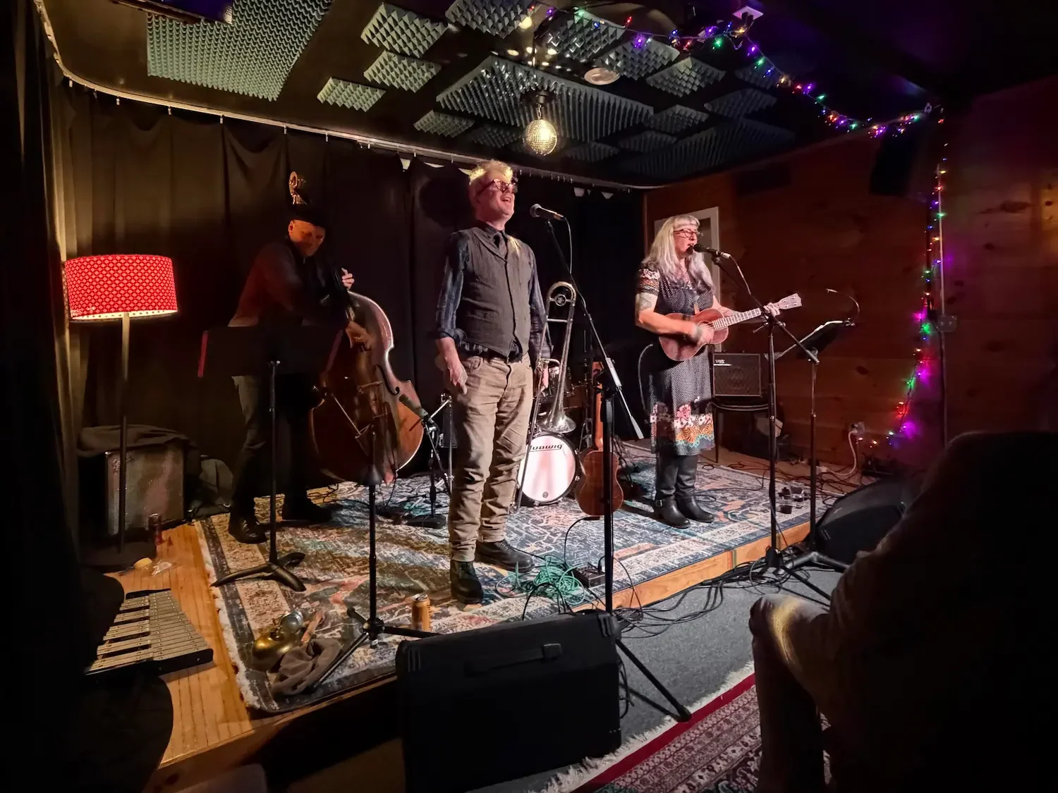 two males and one female musicians performing on a small stage in beacon new york