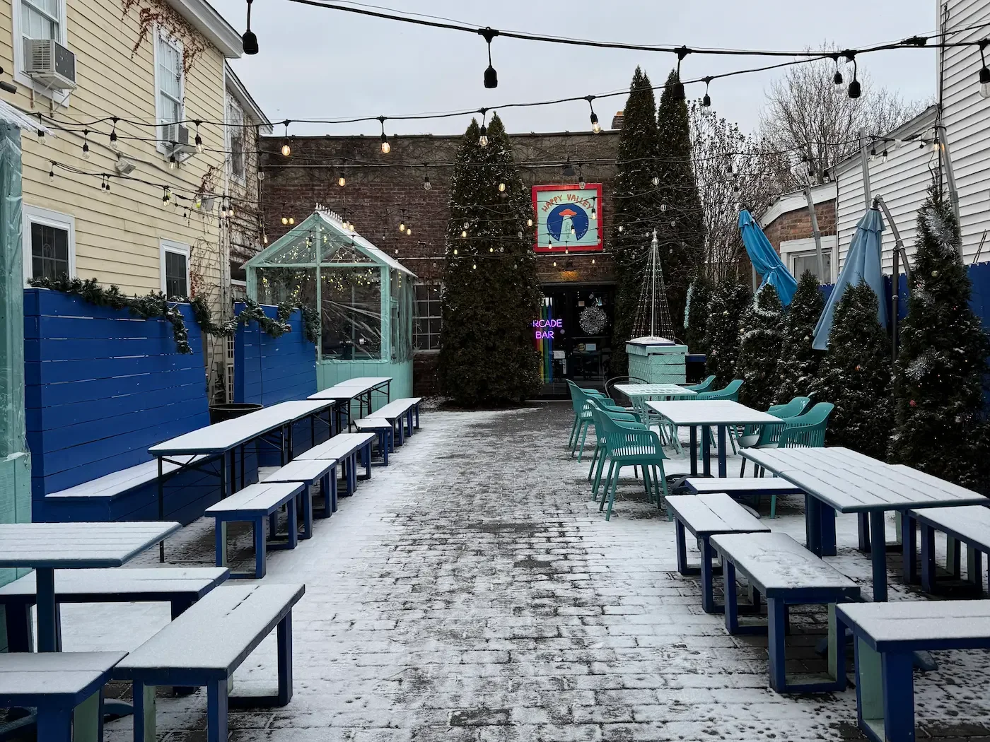 a snow-covered patio of Happy Valley Arcade Bar