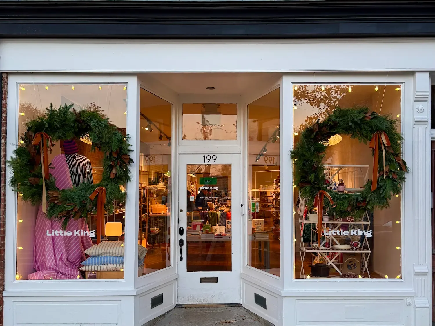 A storefront with two Christmas wreaths adorning the windows on Main Street, Beacon