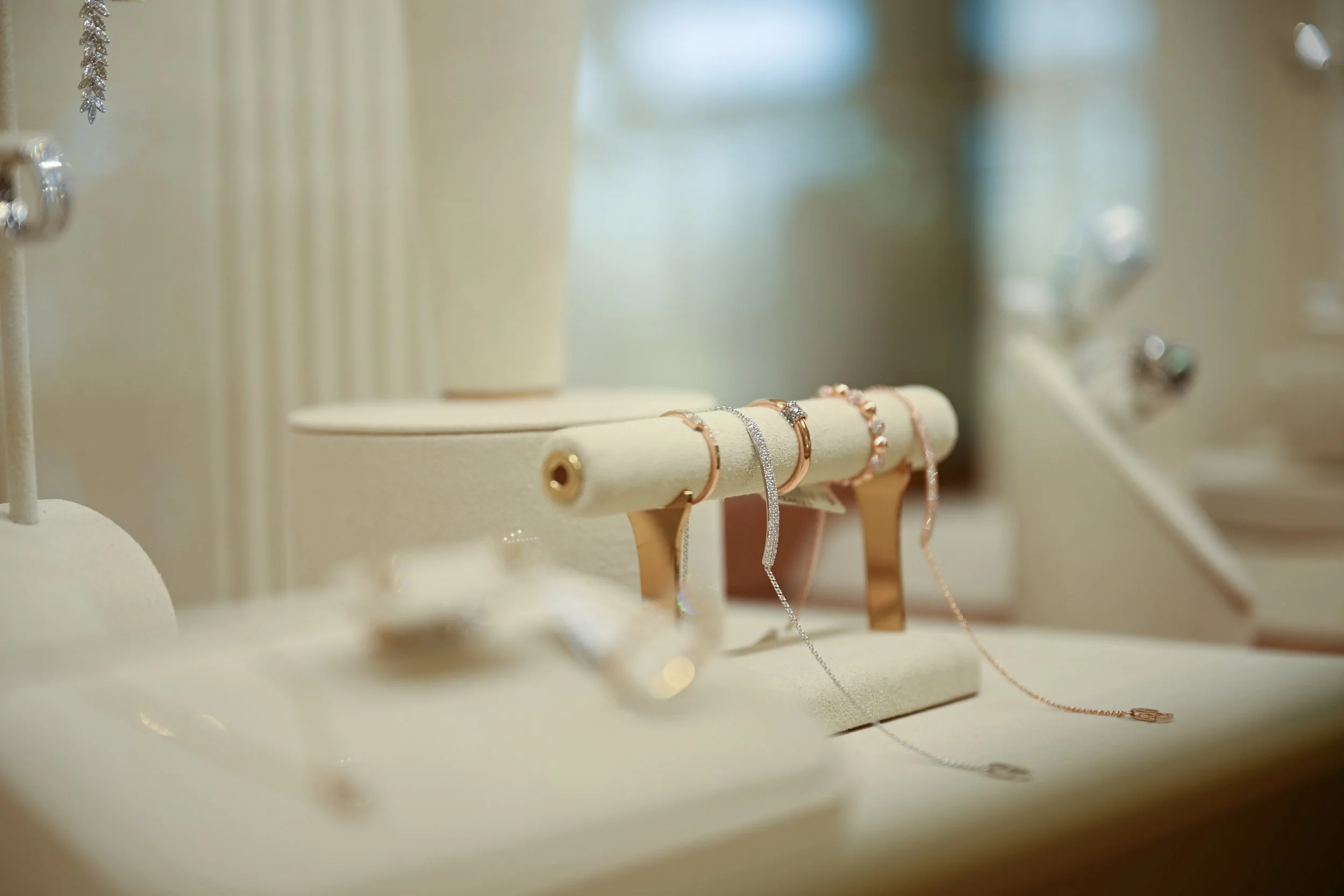 Various bracelets displayed on a jewelry stand inside a store with a blurred background.