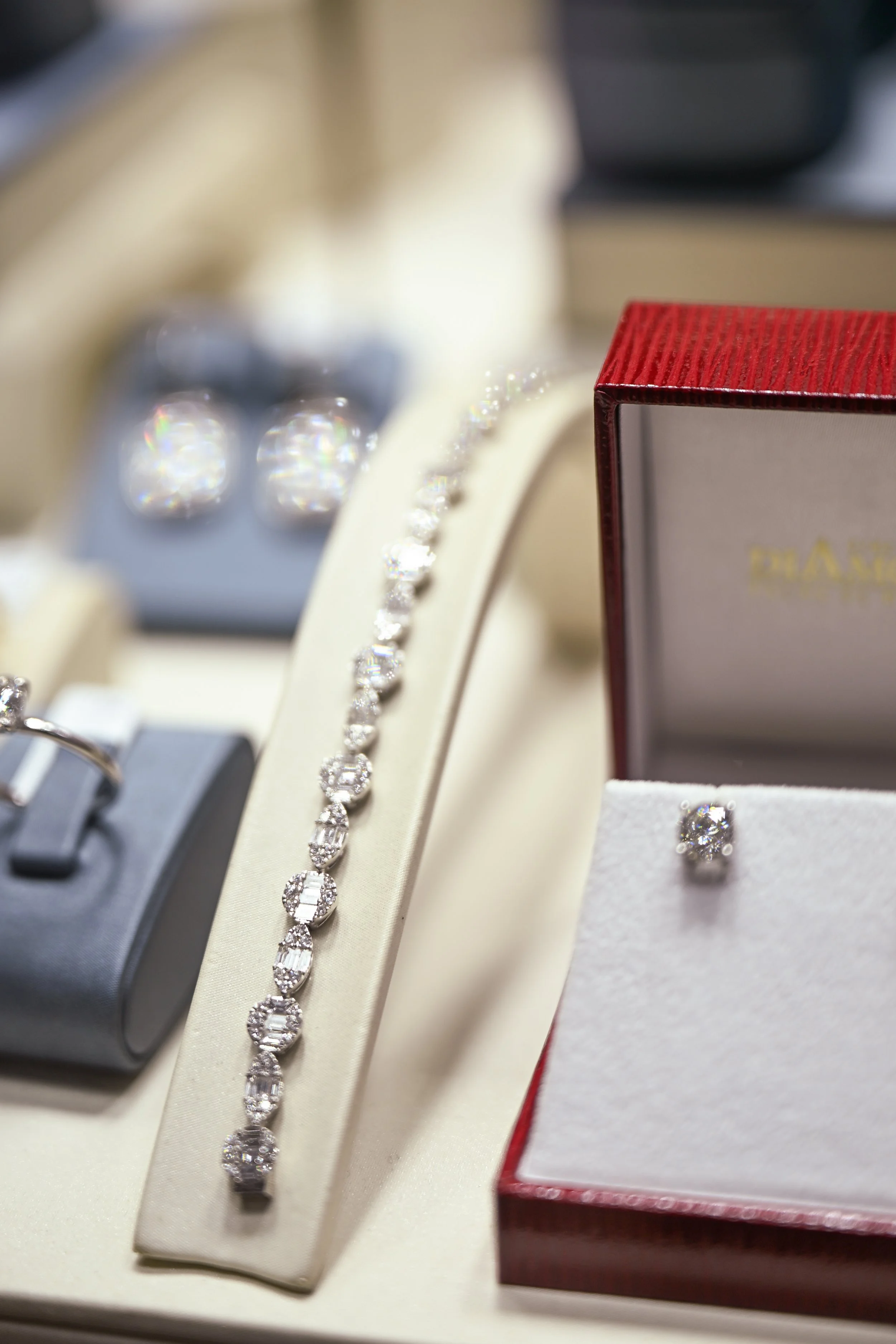 A diamond tennis bracelet and a pair of diamond stud earrings displayed in a jewelry store