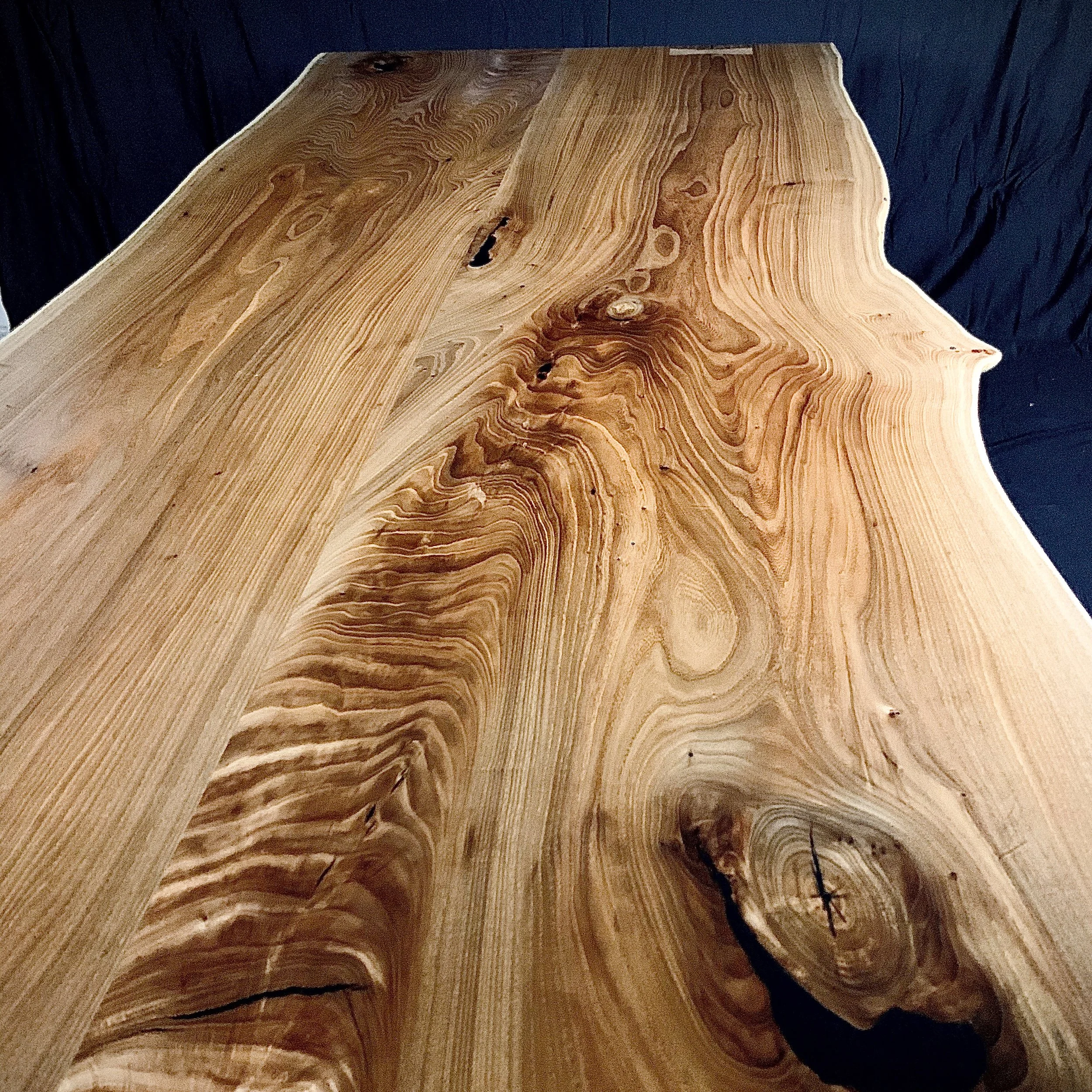 Close-up of a polished wooden table with natural grain patterns and knots.