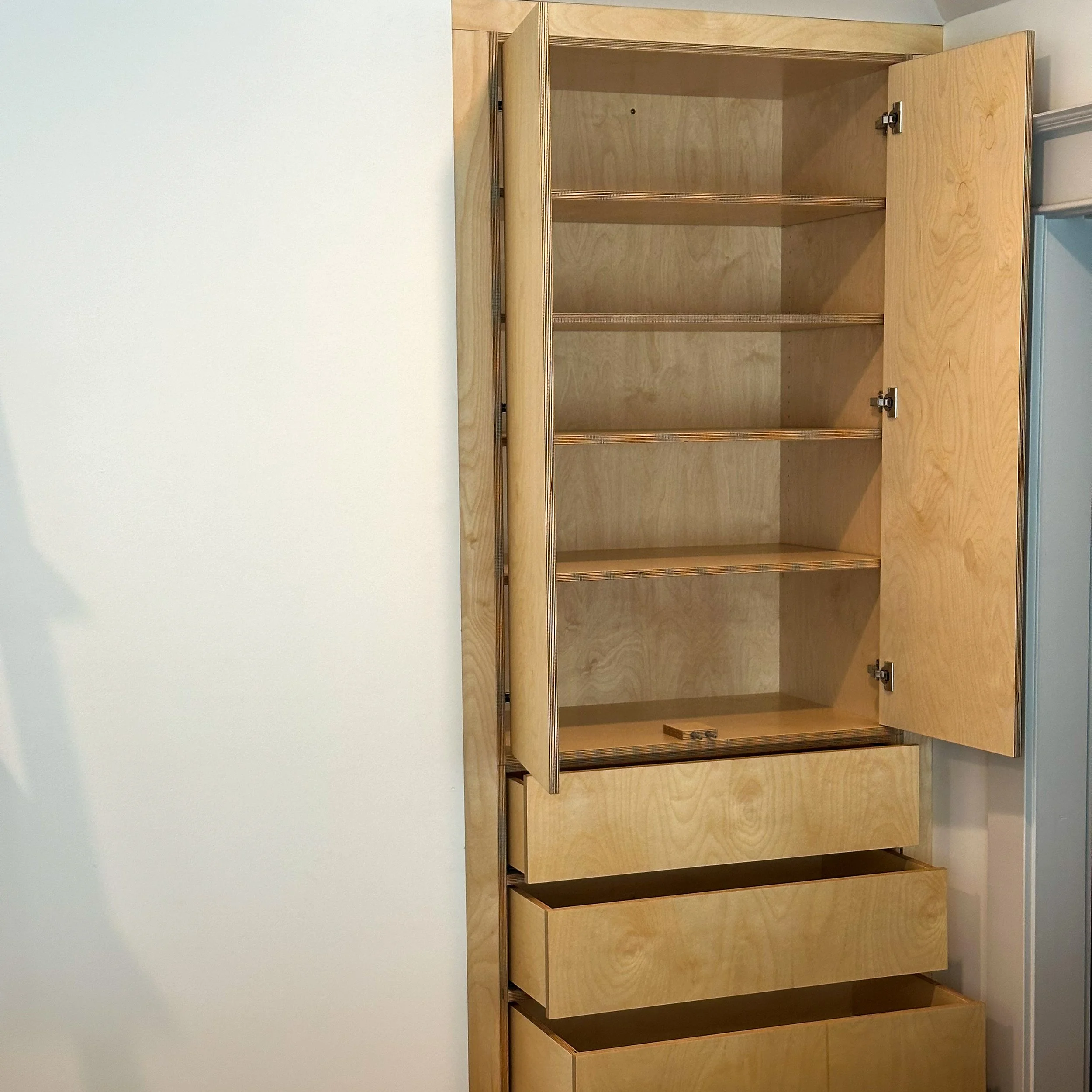 Empty wooden cabinet with open door, five shelves, and three open drawers.