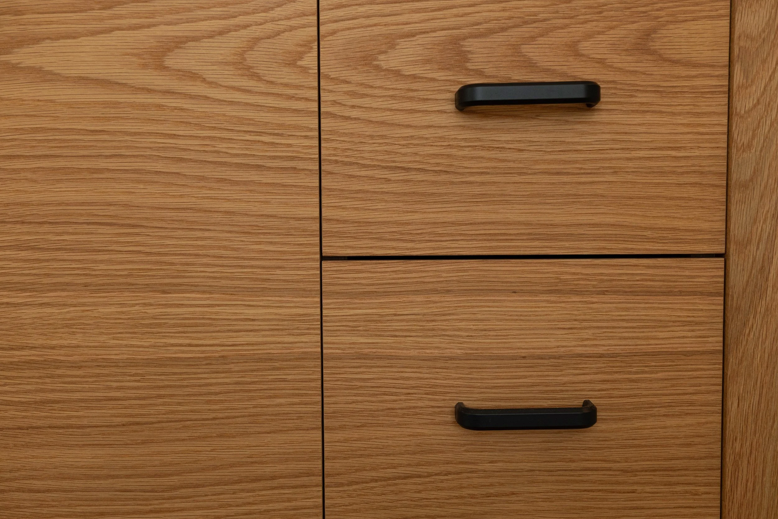 Close-up of wooden cabinet with black handles