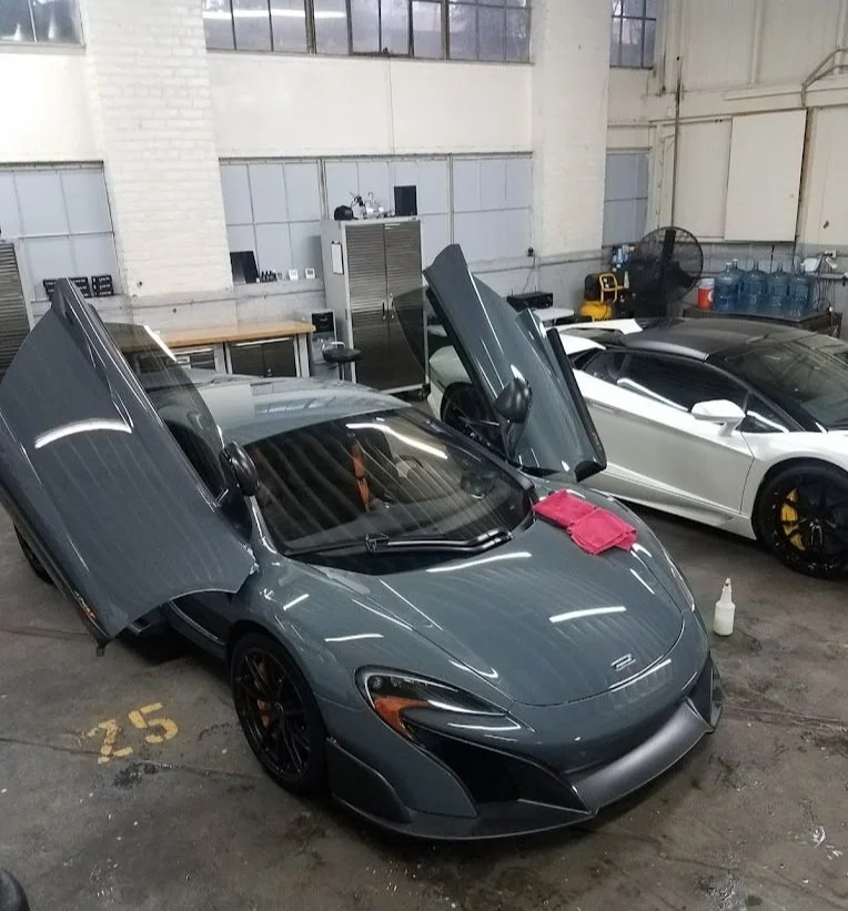 Two exotic super cars with their doors open, showcasing a perfect high-gloss finish from ceramic coating.