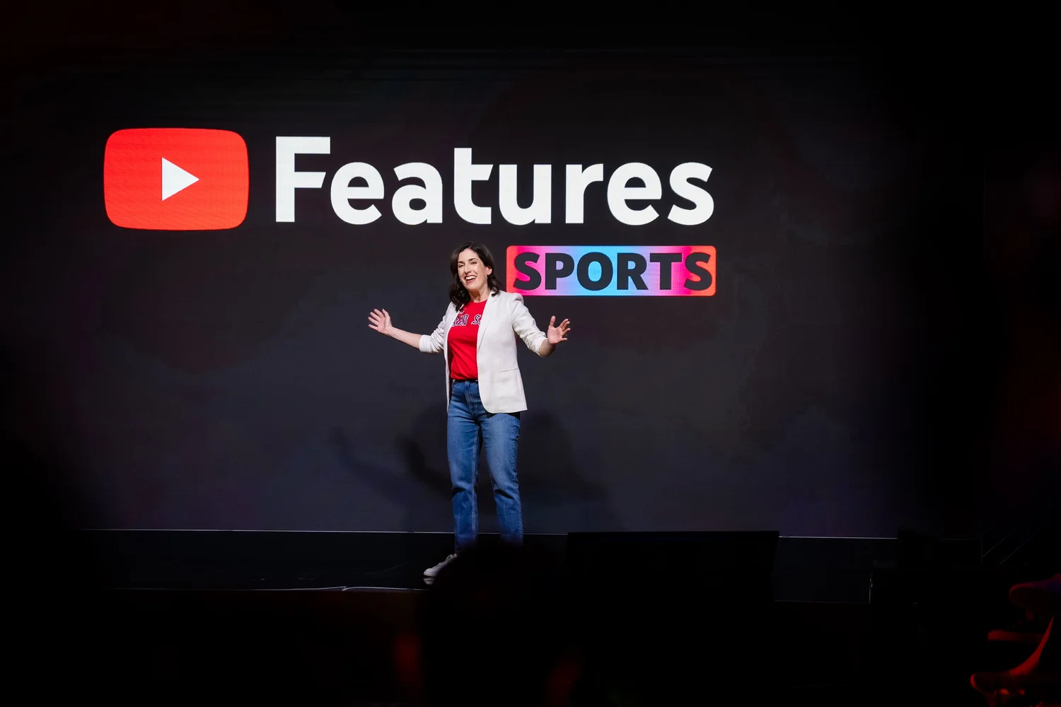 Person on stage with YouTube Features Sports sign