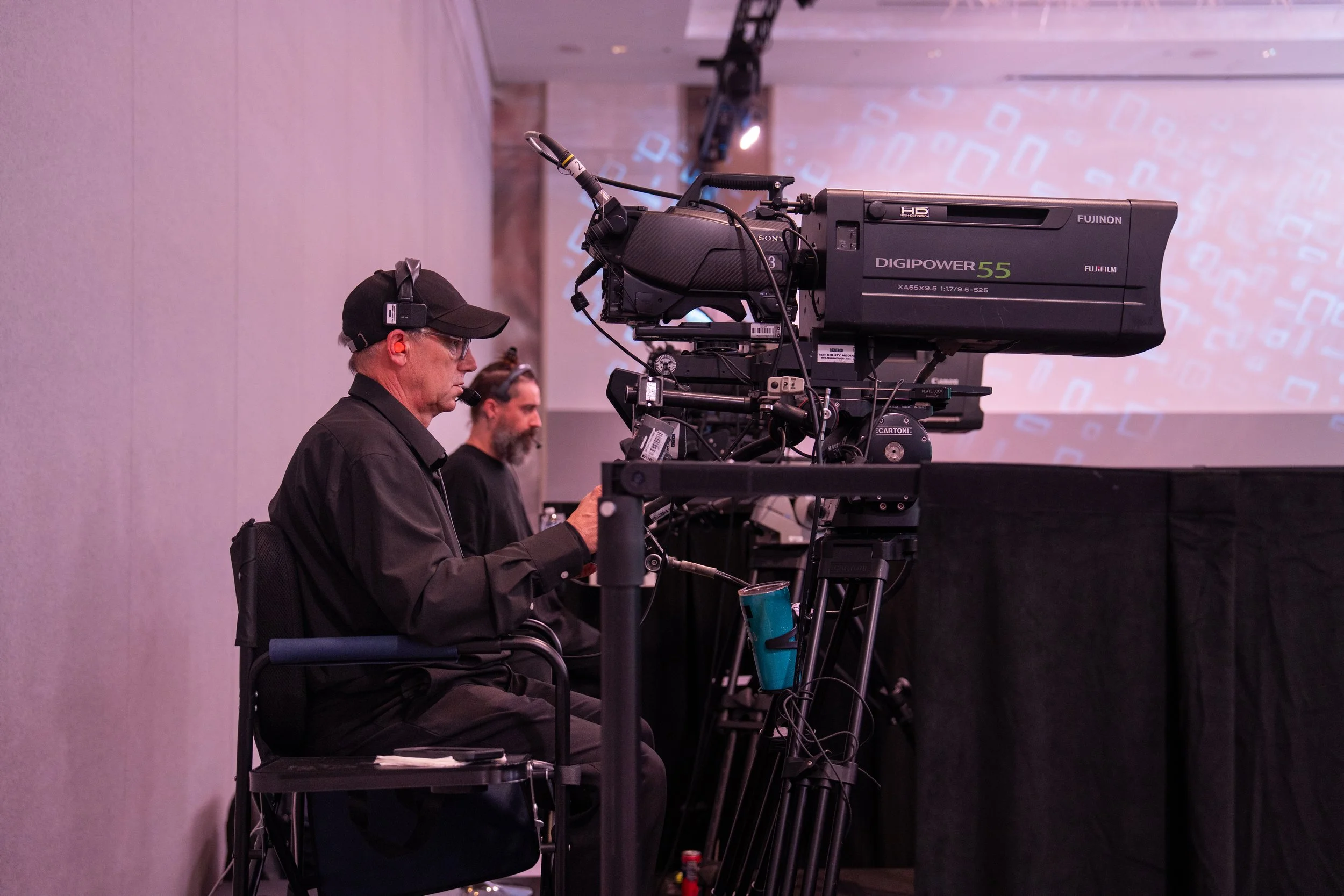 Camera operator filming a corporate event stage for trade show video production in Toronto